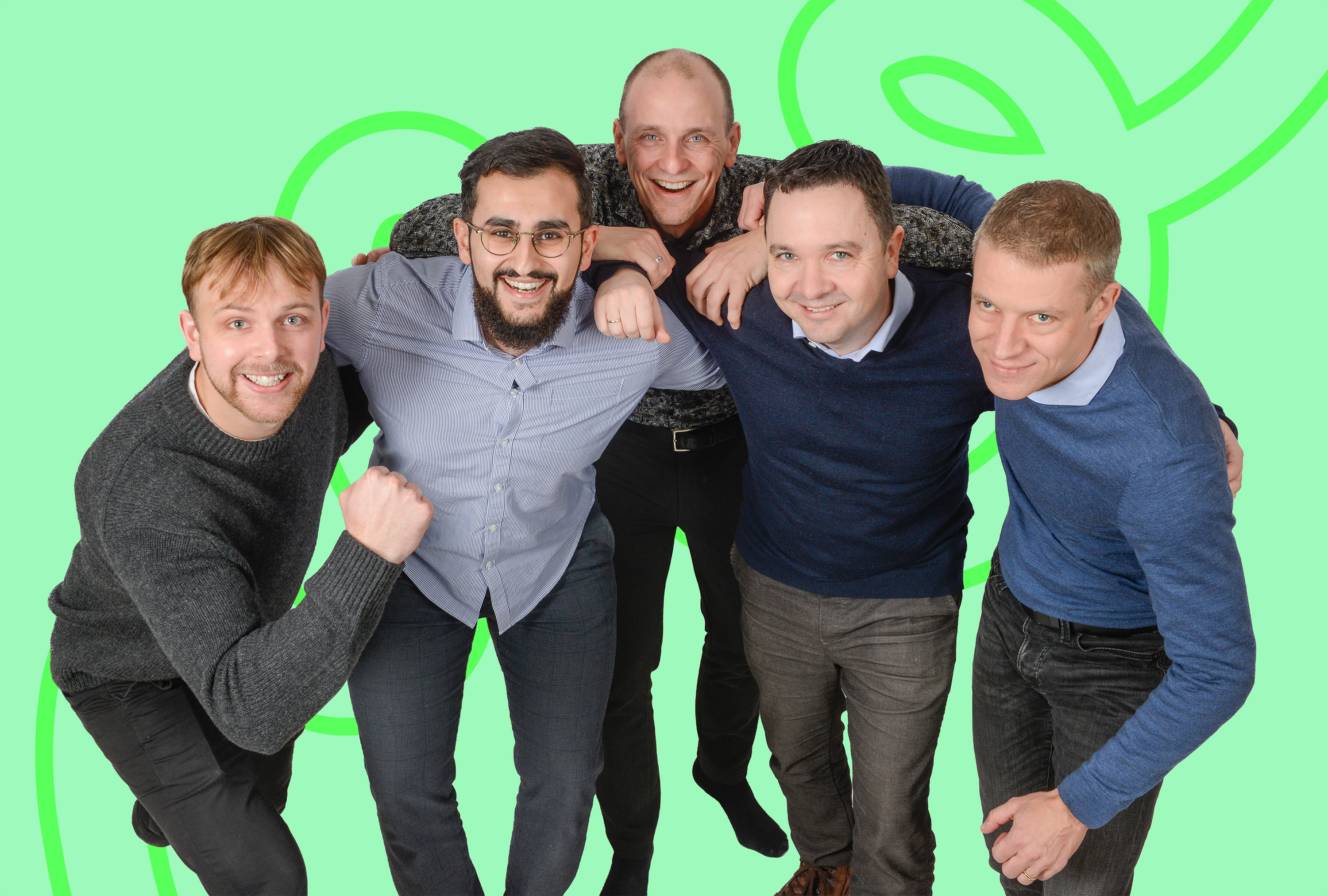 Fem menn sammenlener seg framover, smilende og positive, foran grønn bakgrunn med mønster.