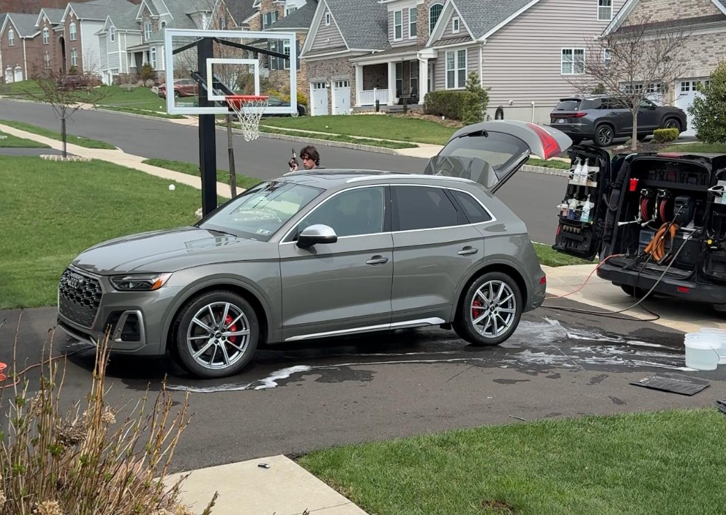 A Vehicle Being Mobile Detailed in A Driveway