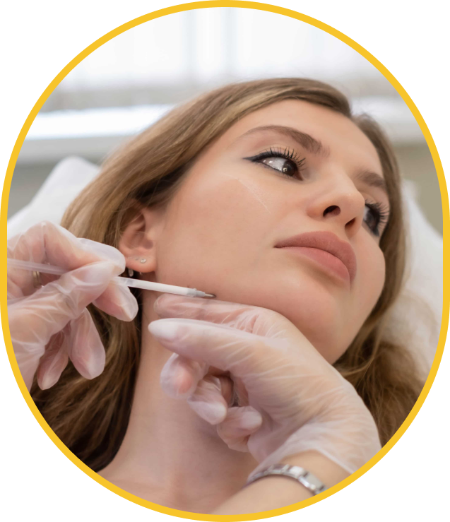 Professionnel ganté effectuant un traitement de «filler» au menton sur une femme allongée en clinique 
