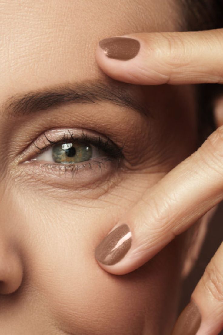 Gros plan de l'œil d'une femme montrant des signes de vieillissement et des zones potentielles pour le traitement de blépharoplastie pour réduire les poches sous les yeux.