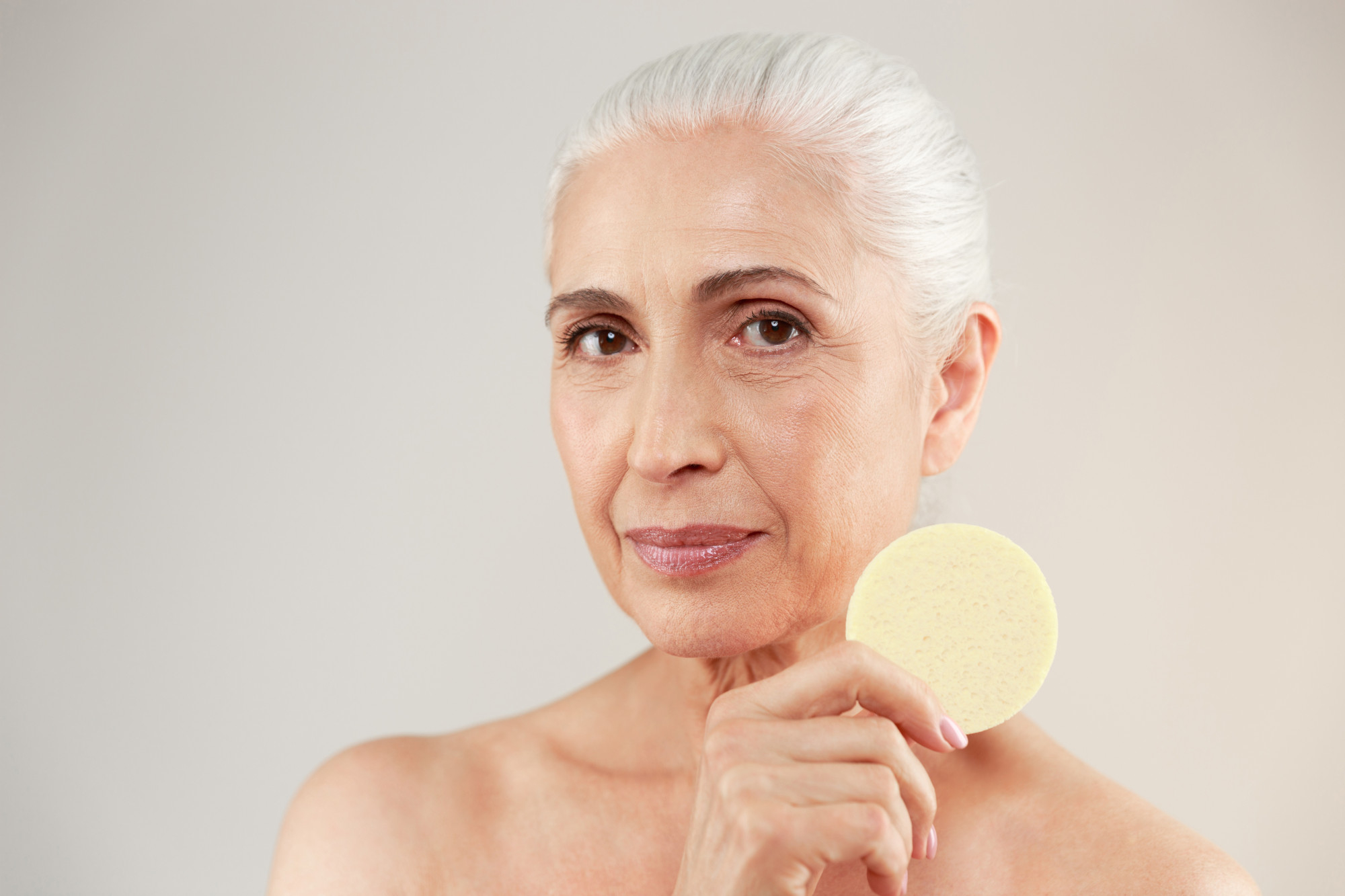 Portrait rapproché d'une femme mature au teint lumineux montrant une tache pigmentaire visage légère sur la pommette et le contour des yeux.