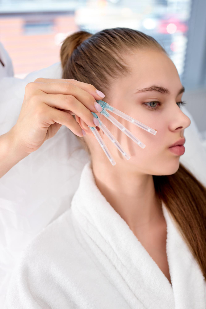 Professionnelle tenant des bâtonnets en verre près de la joue pour le contour du visage.