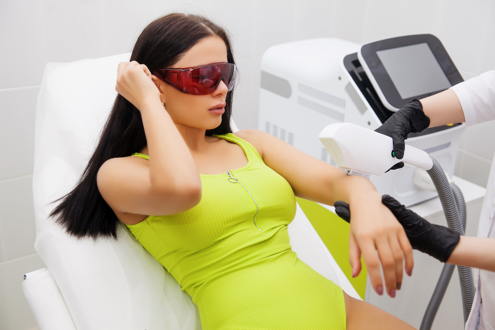 Femme assise portant des lunettes de protection rouges près de l'appareil avant une séance IPL.