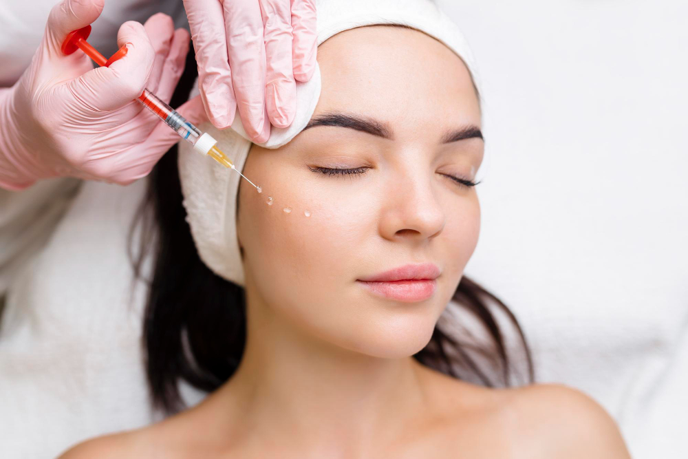 Professionnelle effectuant le traitement par PRP près de la tempe et de la racine des cheveux.