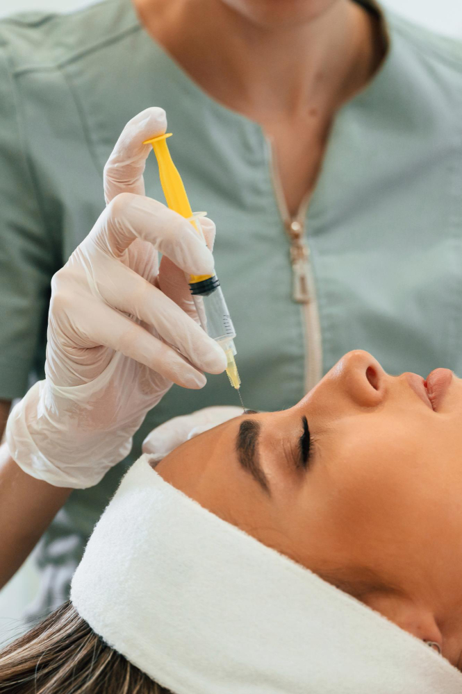 Professionnelle injectant le front dans le cadre d'un traitement de régénération cutanée.