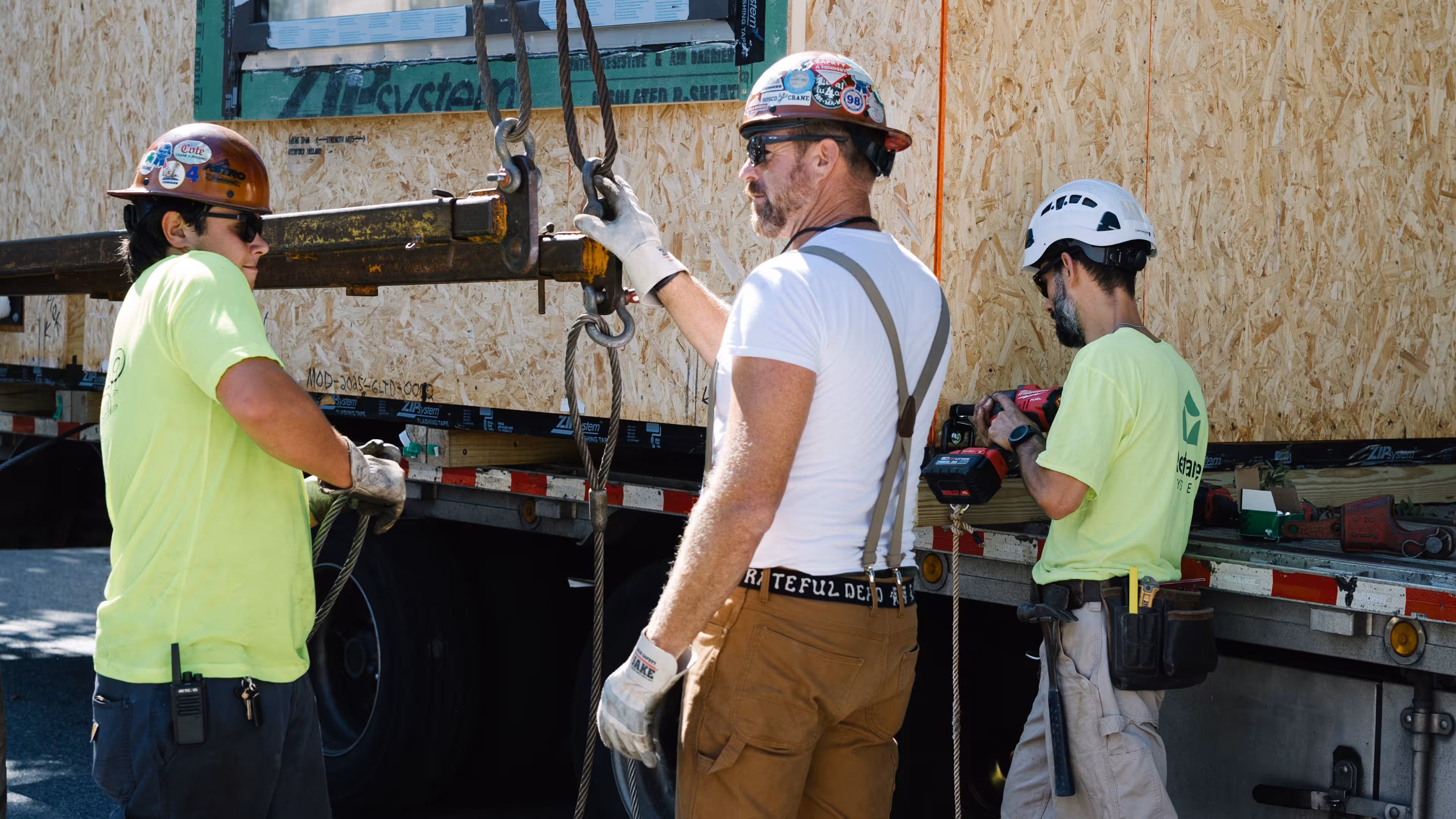 Reframe Systems crew rigging a prefabricated module on a flatbed delivery truck