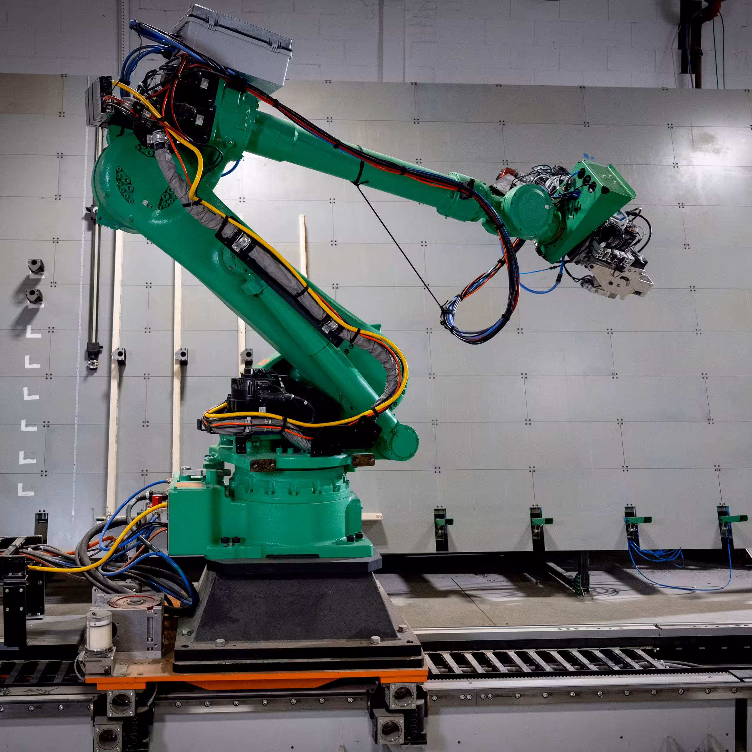 Green robotic arm on a track inside the Reframe Systems microfactory