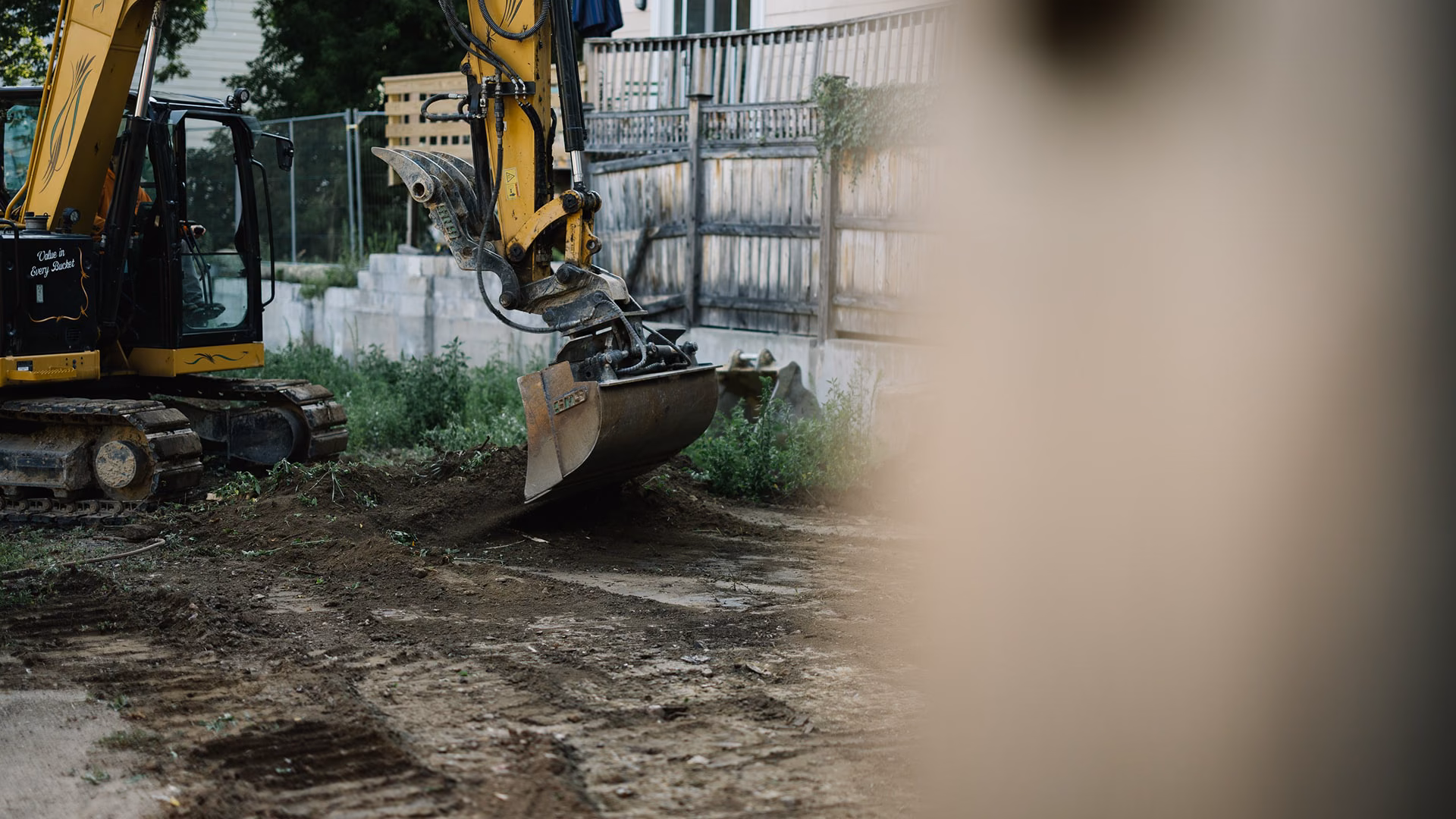 Excavator clearing a residential lot at an early-stage Reframe Systems build site