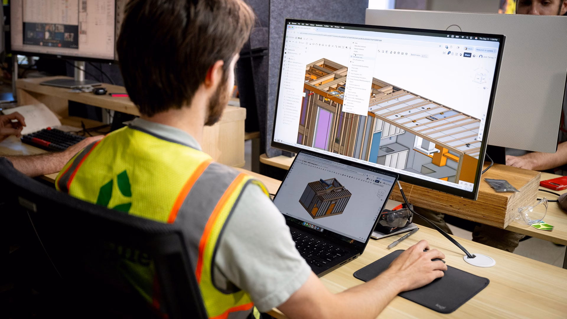 Reframe Systems designer reviewing a 3D building model on screen at a workstation