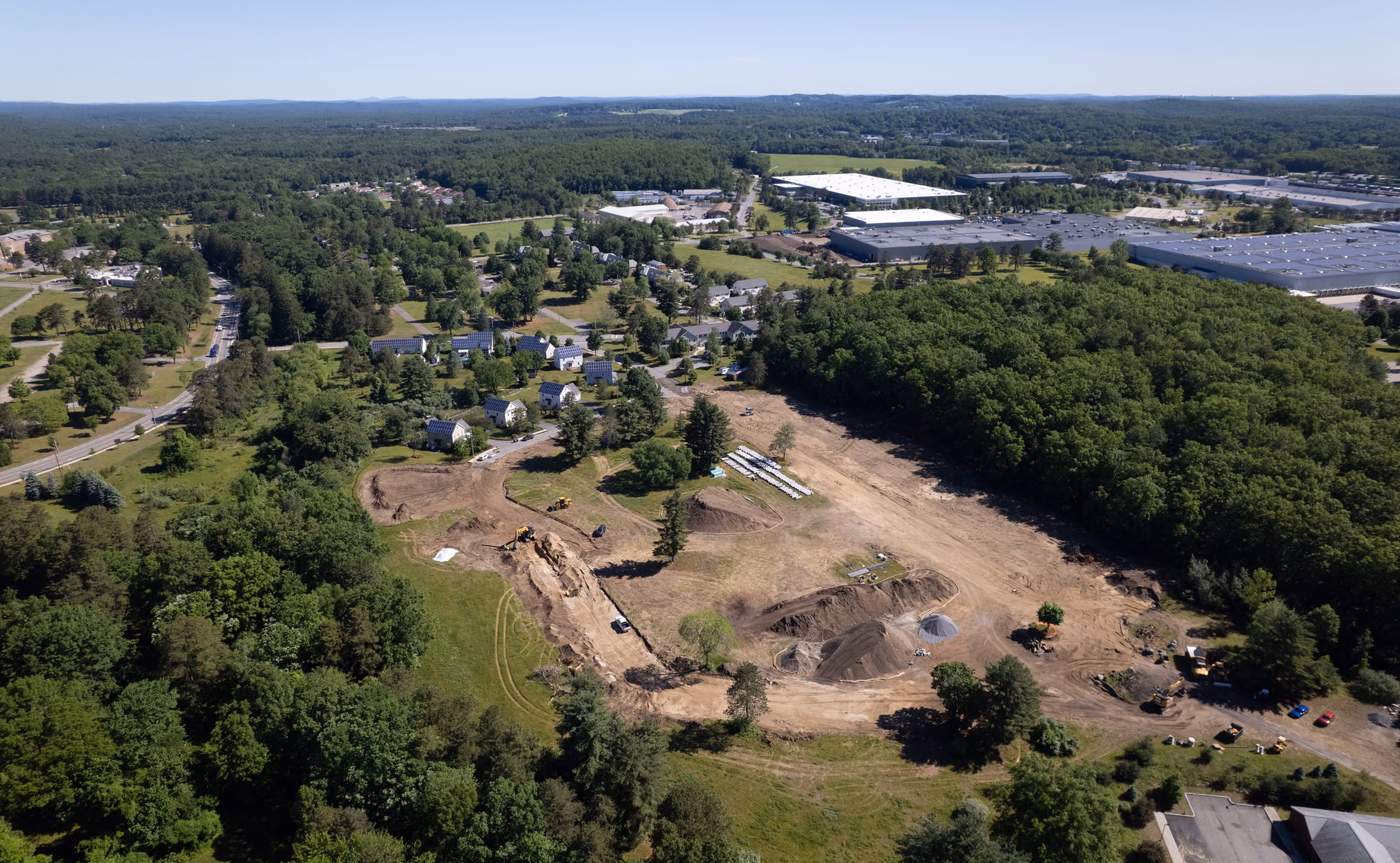 Aerial view of the Adams Circle construction site surrounded by dense woodland.