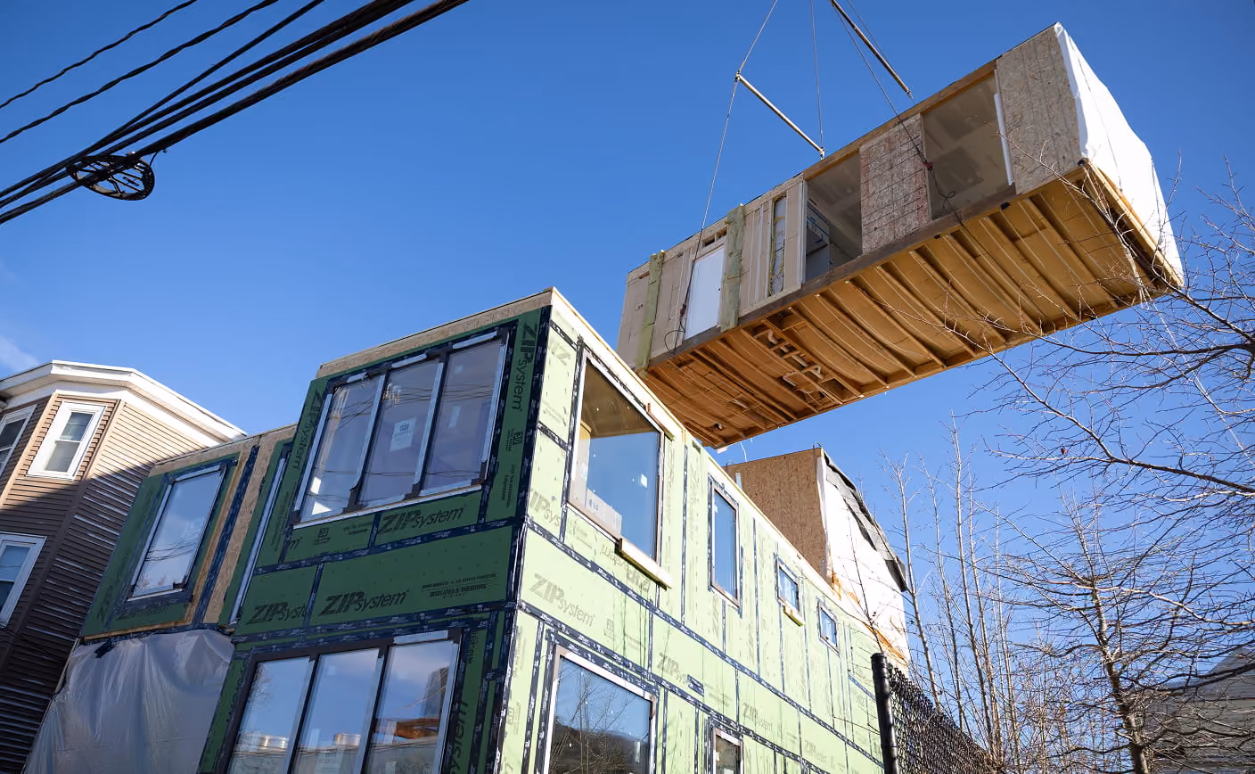 Cross East three story house building with a crane