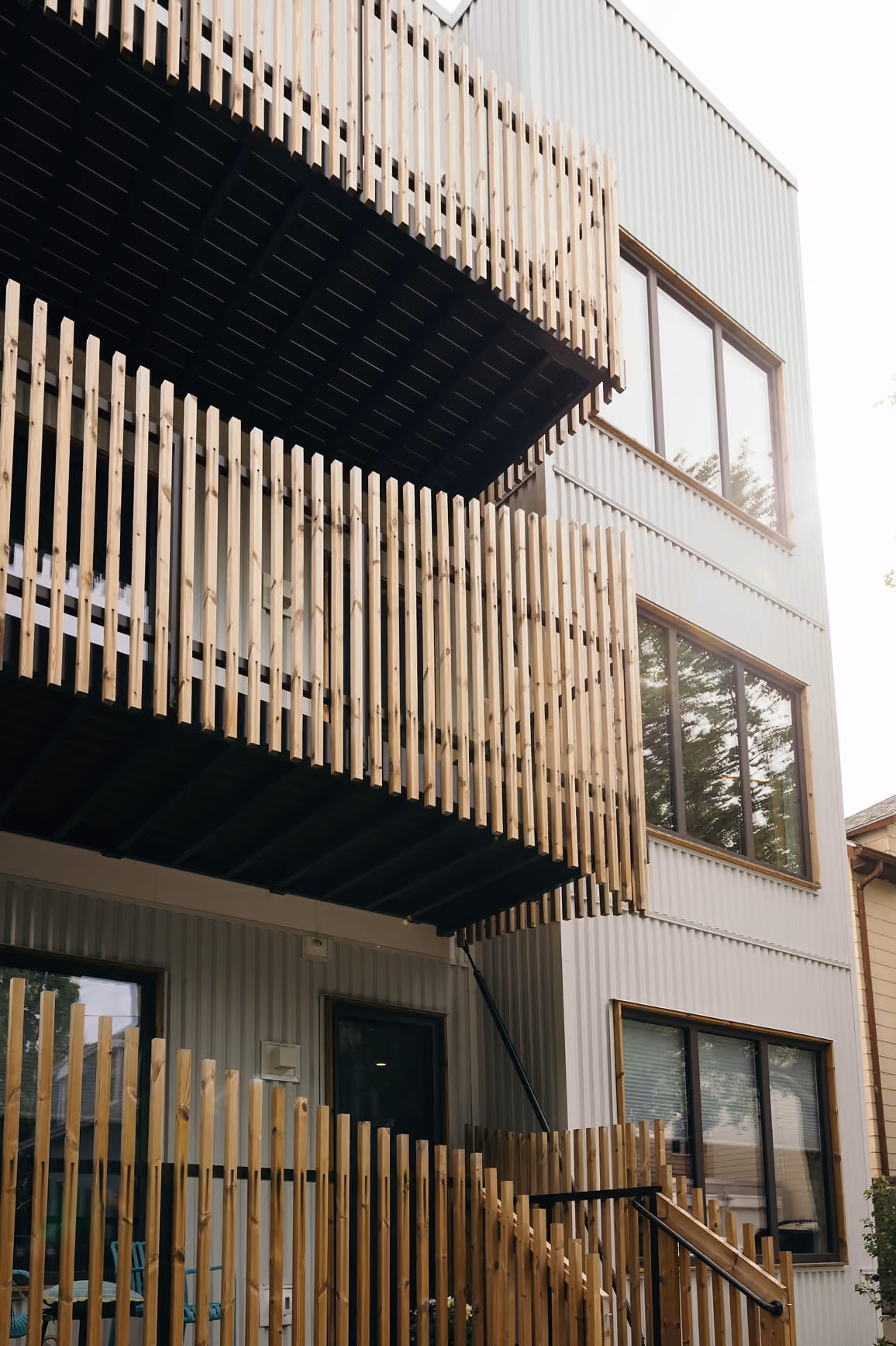 Close-up of a modern townhouse exterior with stacked balconies and contrasting siding.