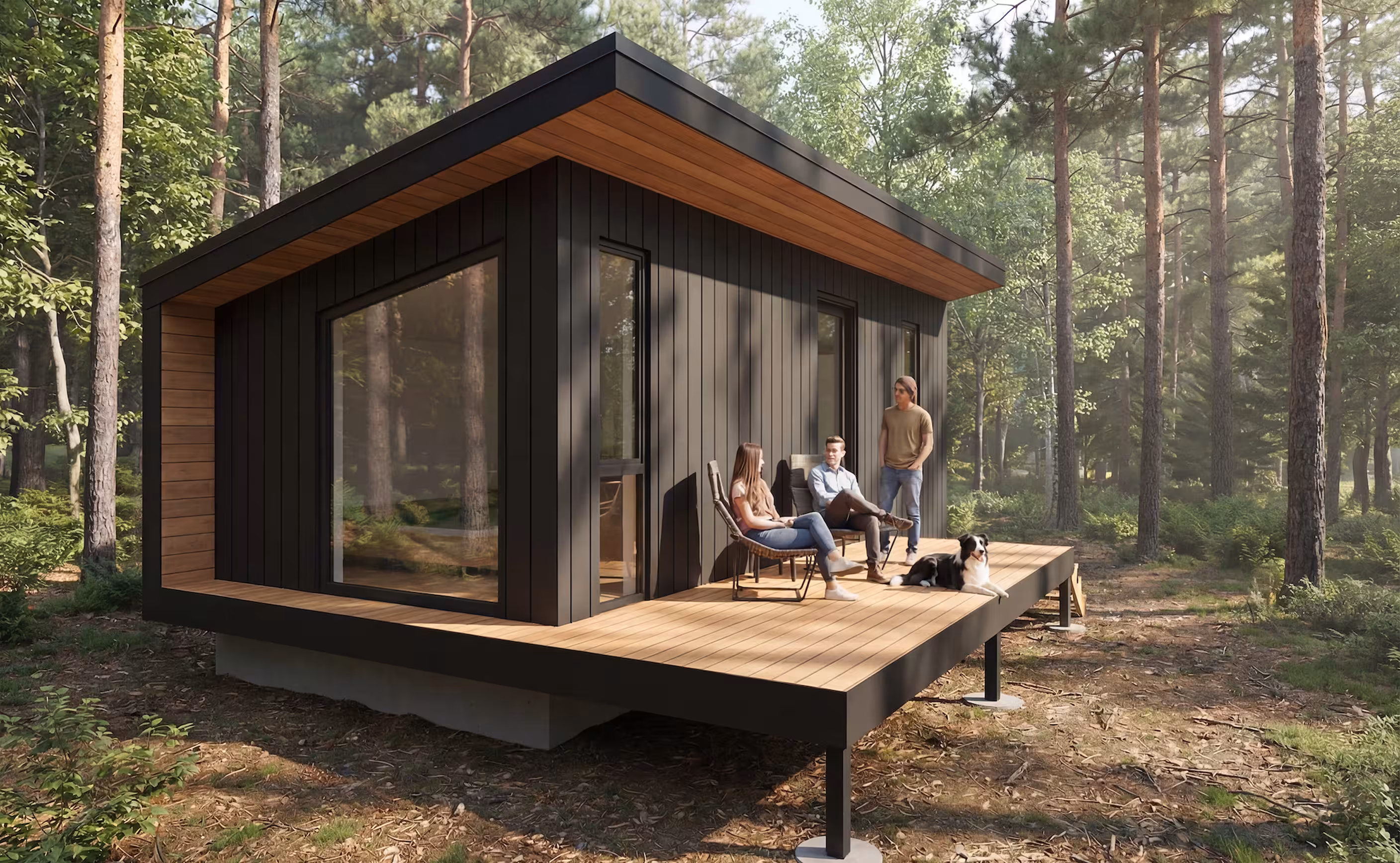 Modern dark-clad cabin in a forest with a large wooden deck, where three people relax with a dog.