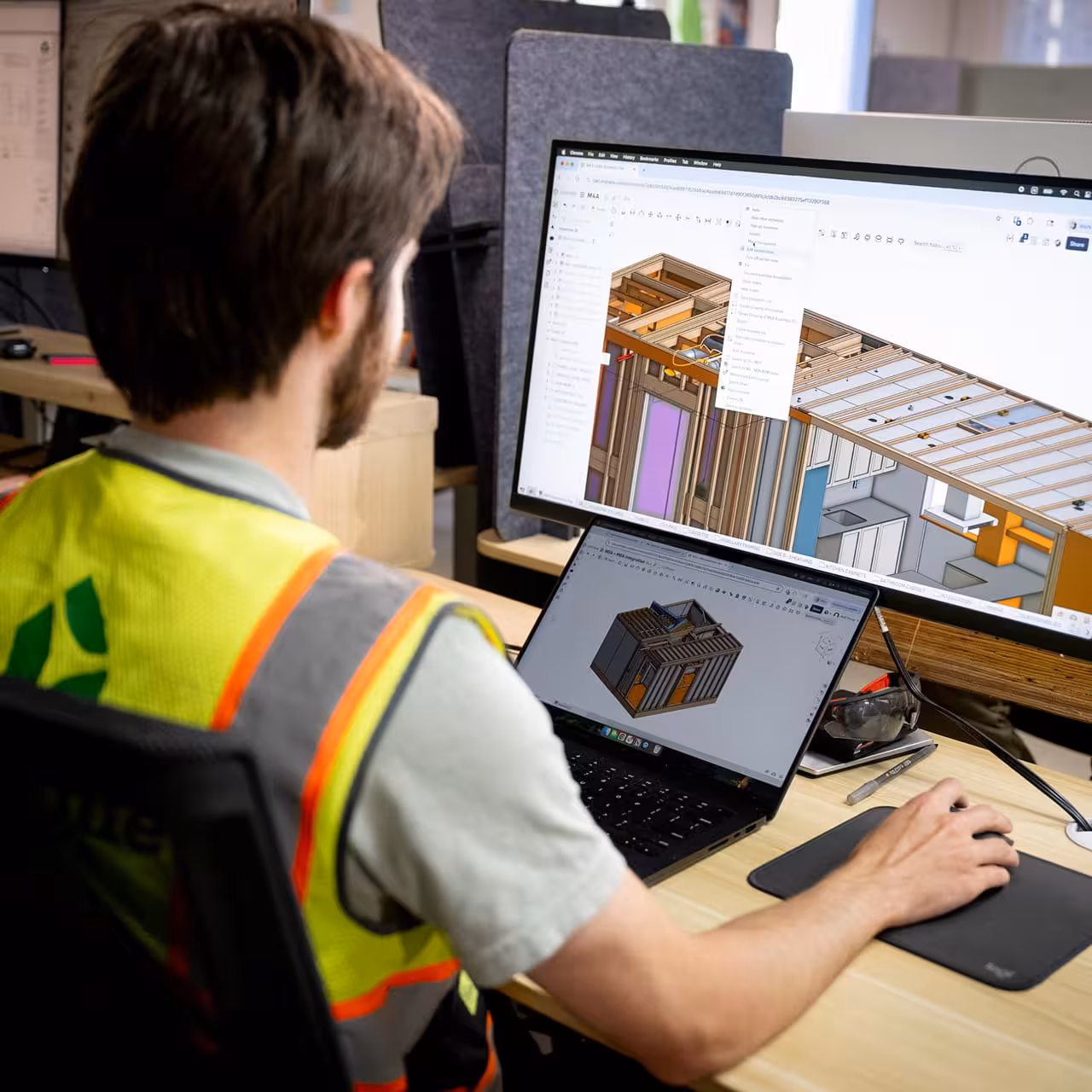 Engineer designing a modular home using 3D modeling software
