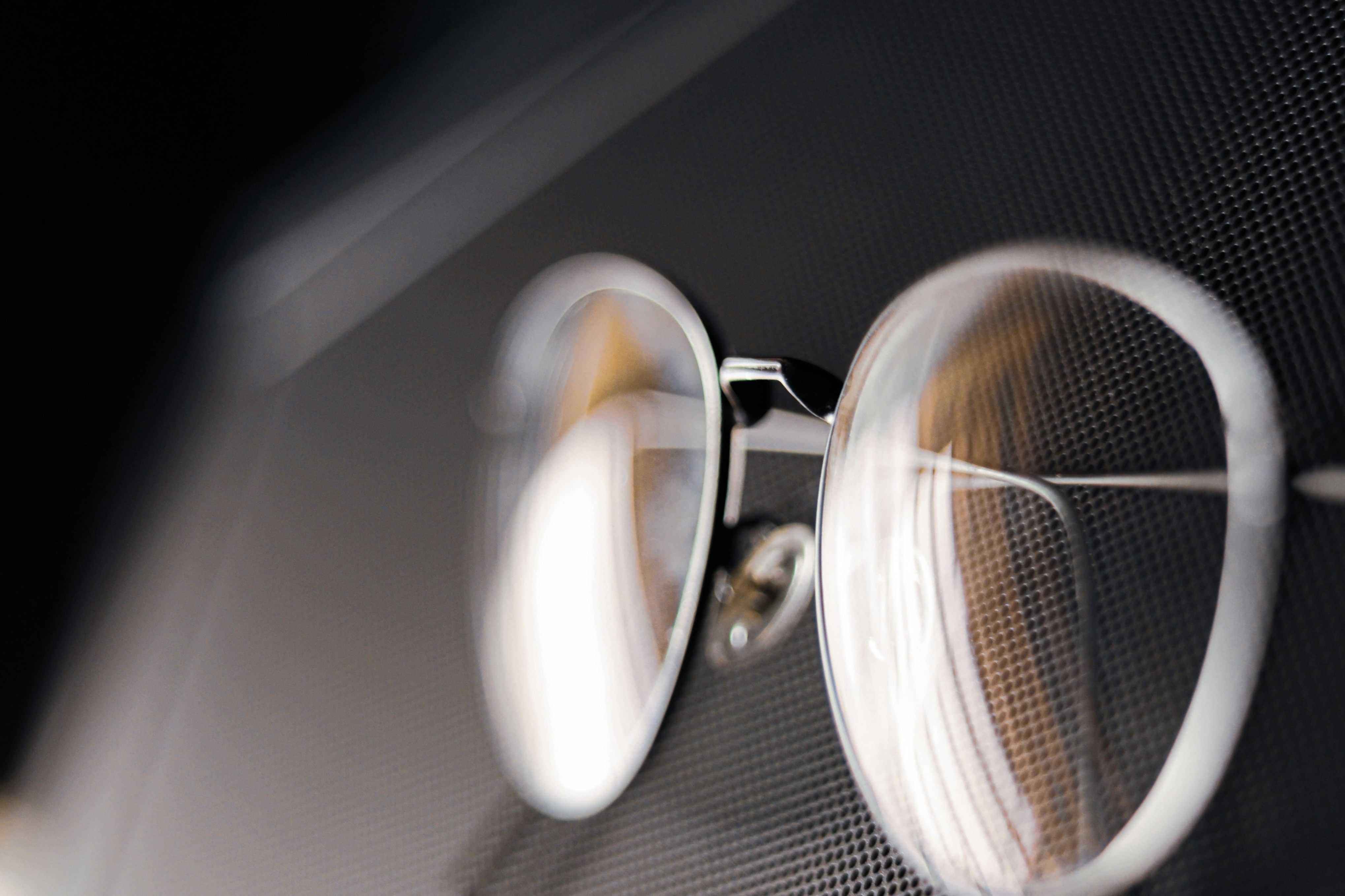 Close-up of round eyeglasses with transparent lenses on textured background