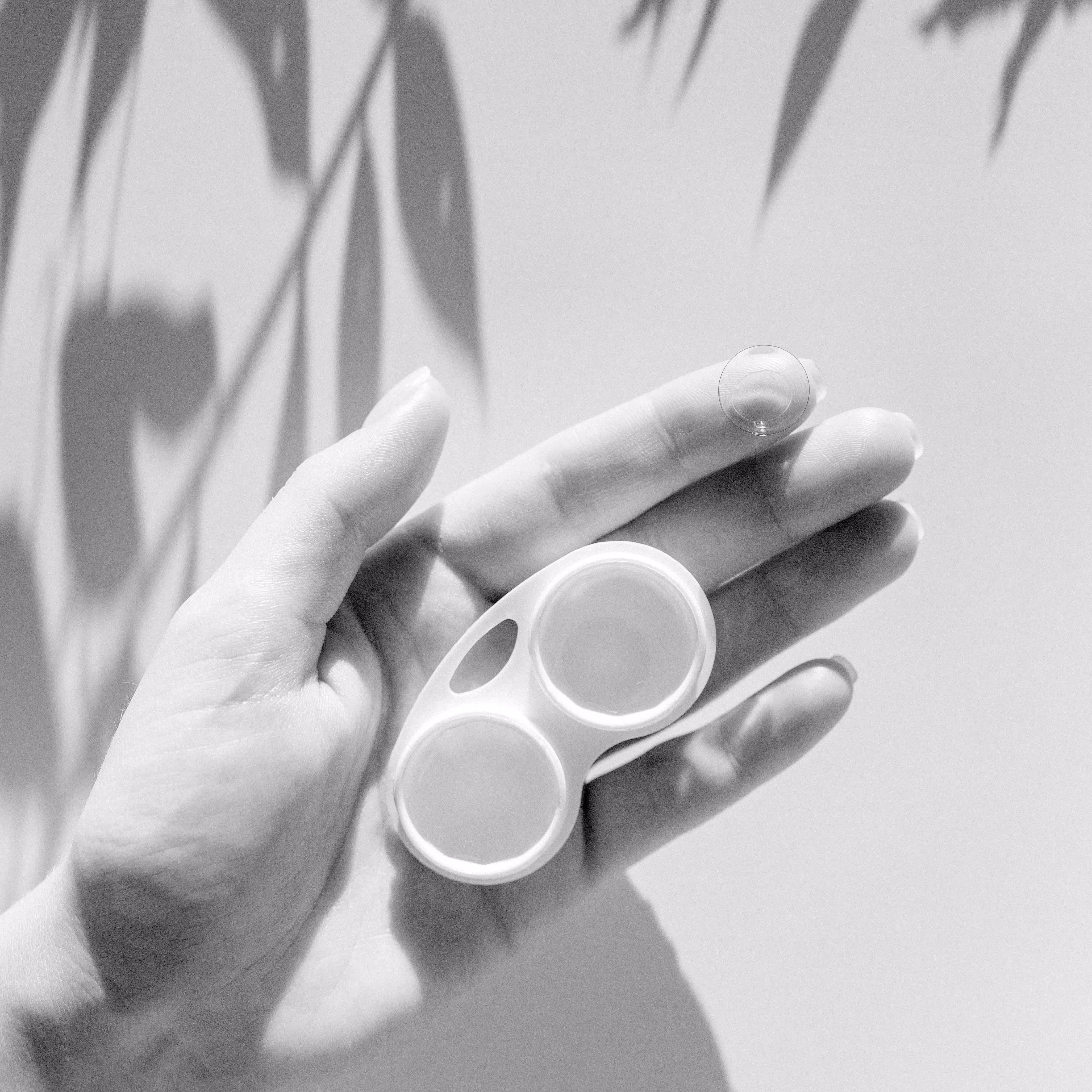 Hand holding white minimalist object with two circular openings
