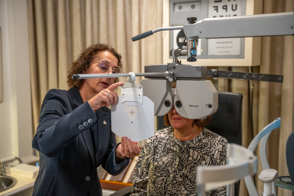Eye doctor performing vision test with professional optical equipment