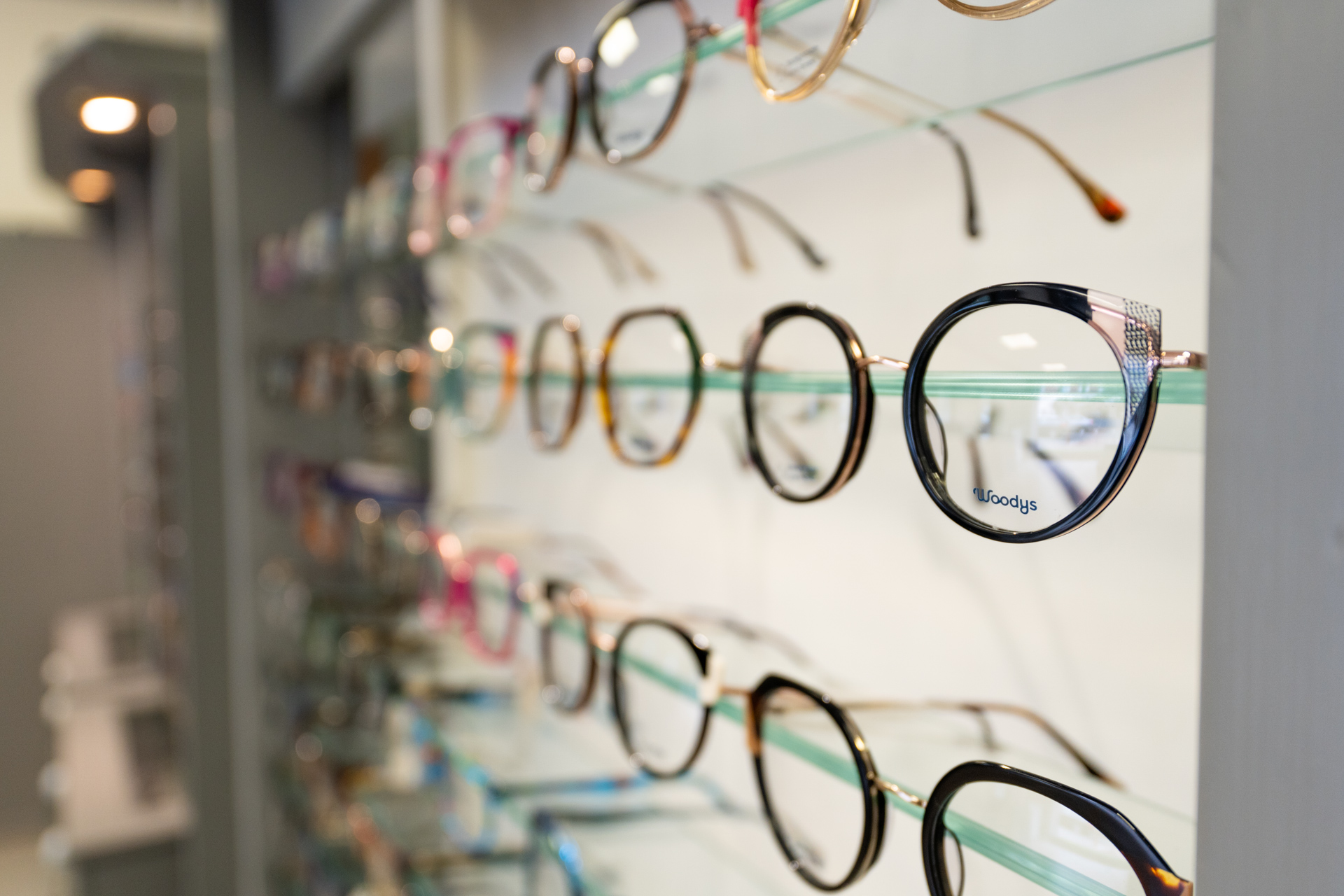 Colorful eyeglasses displayed on shelves in an optical store