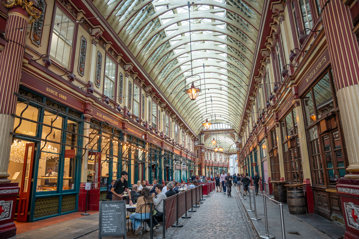 Ornate Victorian glass-roofed Leadenhall Market with shops and people
