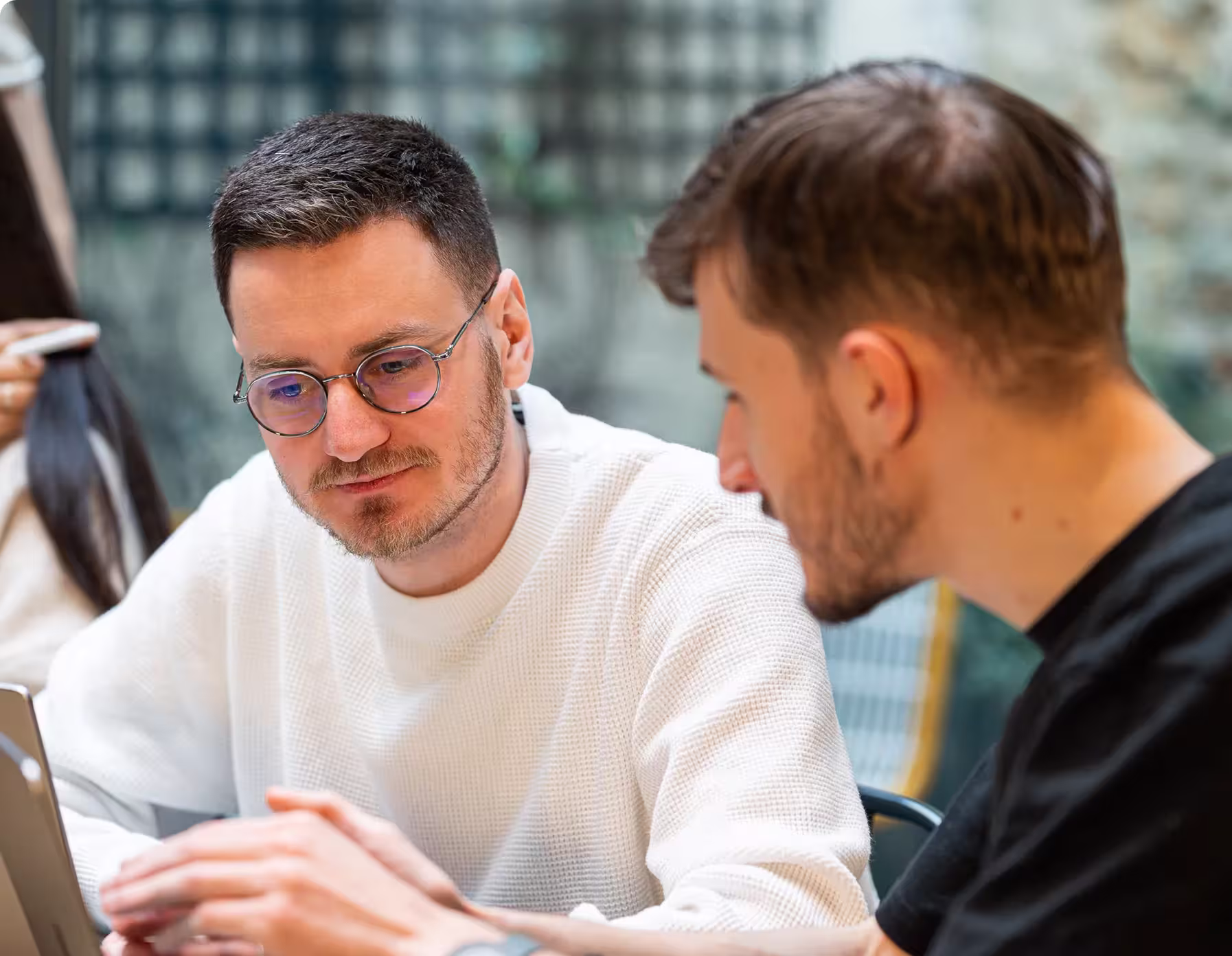 Two Digidop team members discussing during a strategy workshop, focused on a computer screen.