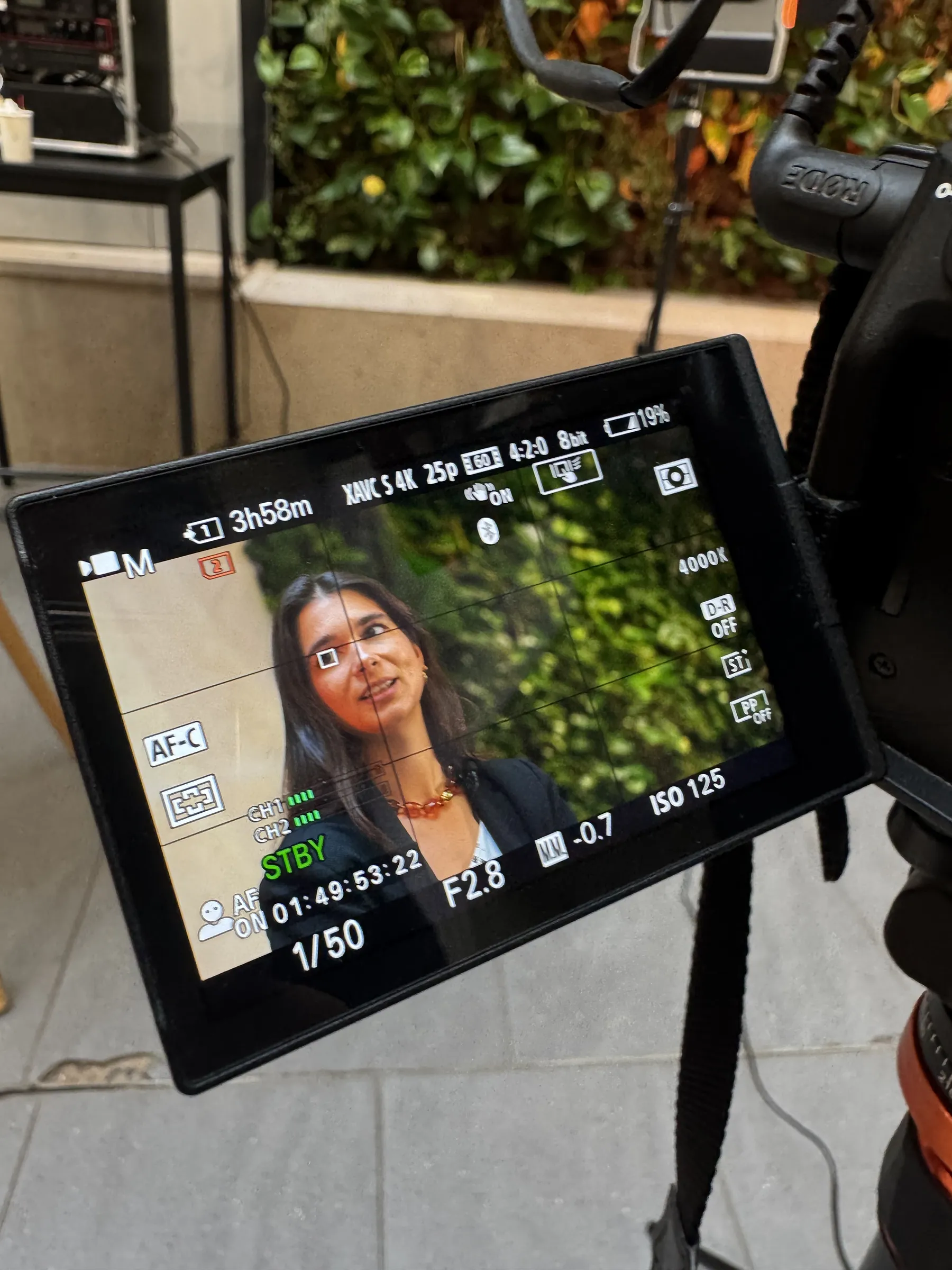 Vue de l’écran d’une caméra filmant une intervenante lors d’un interview en intérieur.