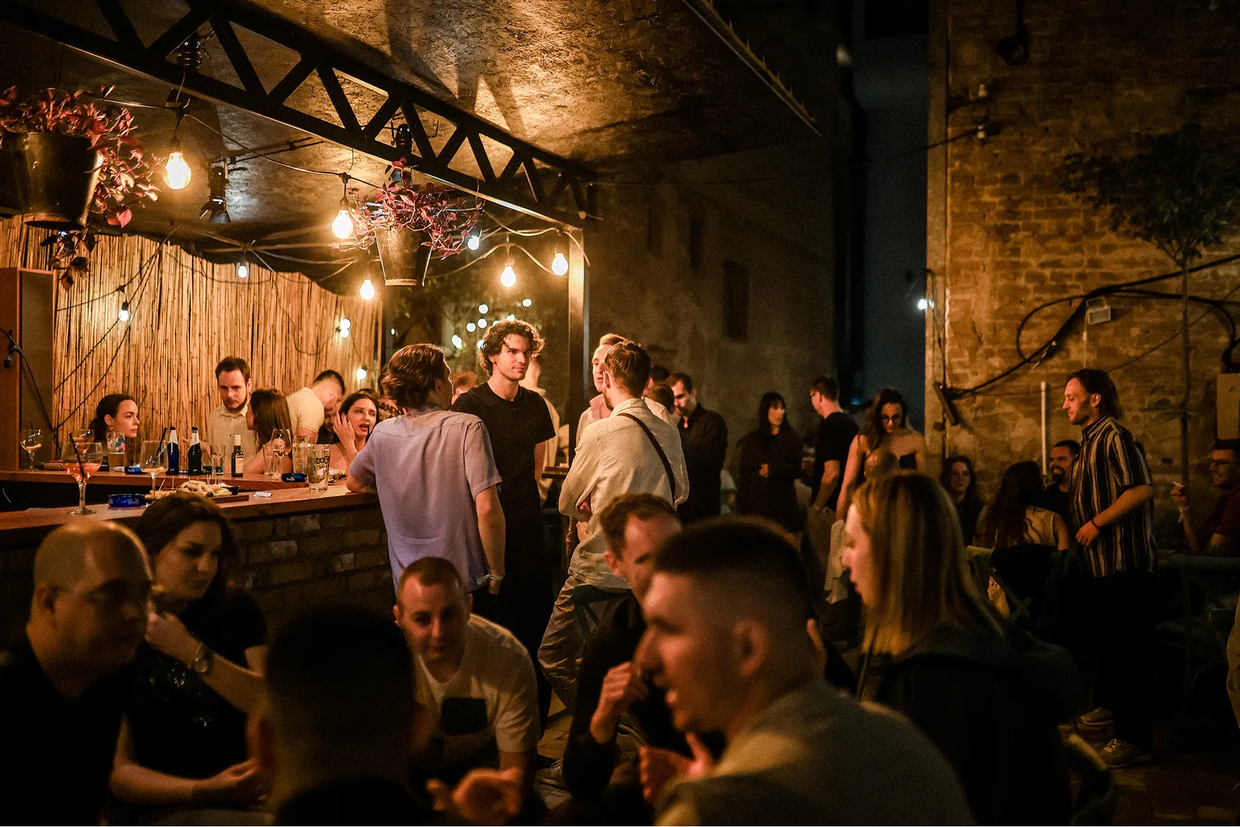 Soirée afterparty de la FLOWconf 2025, avec des participants discutant dans une ambiance nocturne chaleureuse.