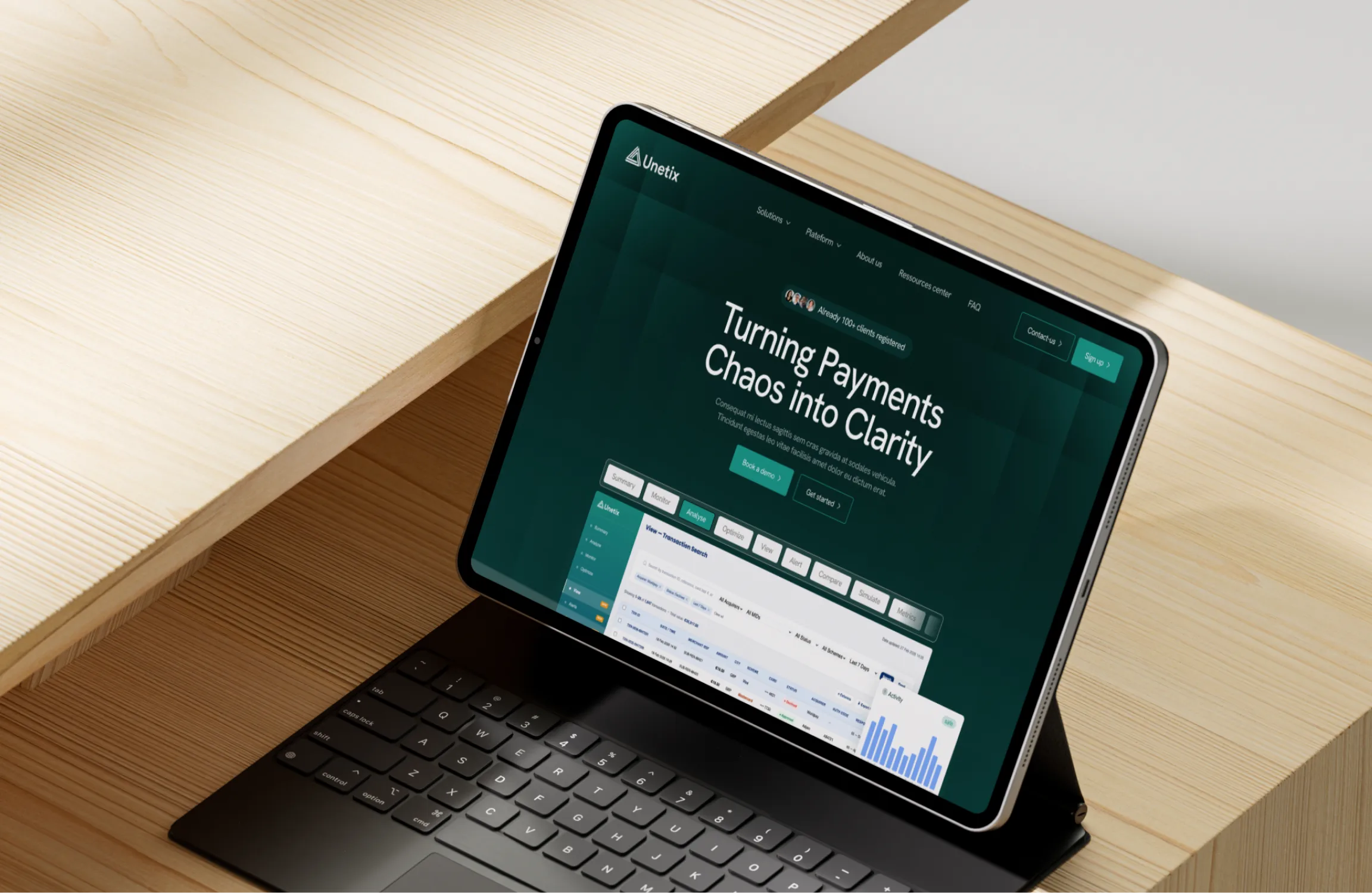 Tablette avec clavier sur un bureau en bois affichant le site Unetix : transformer le chaos des paiements en clarté.