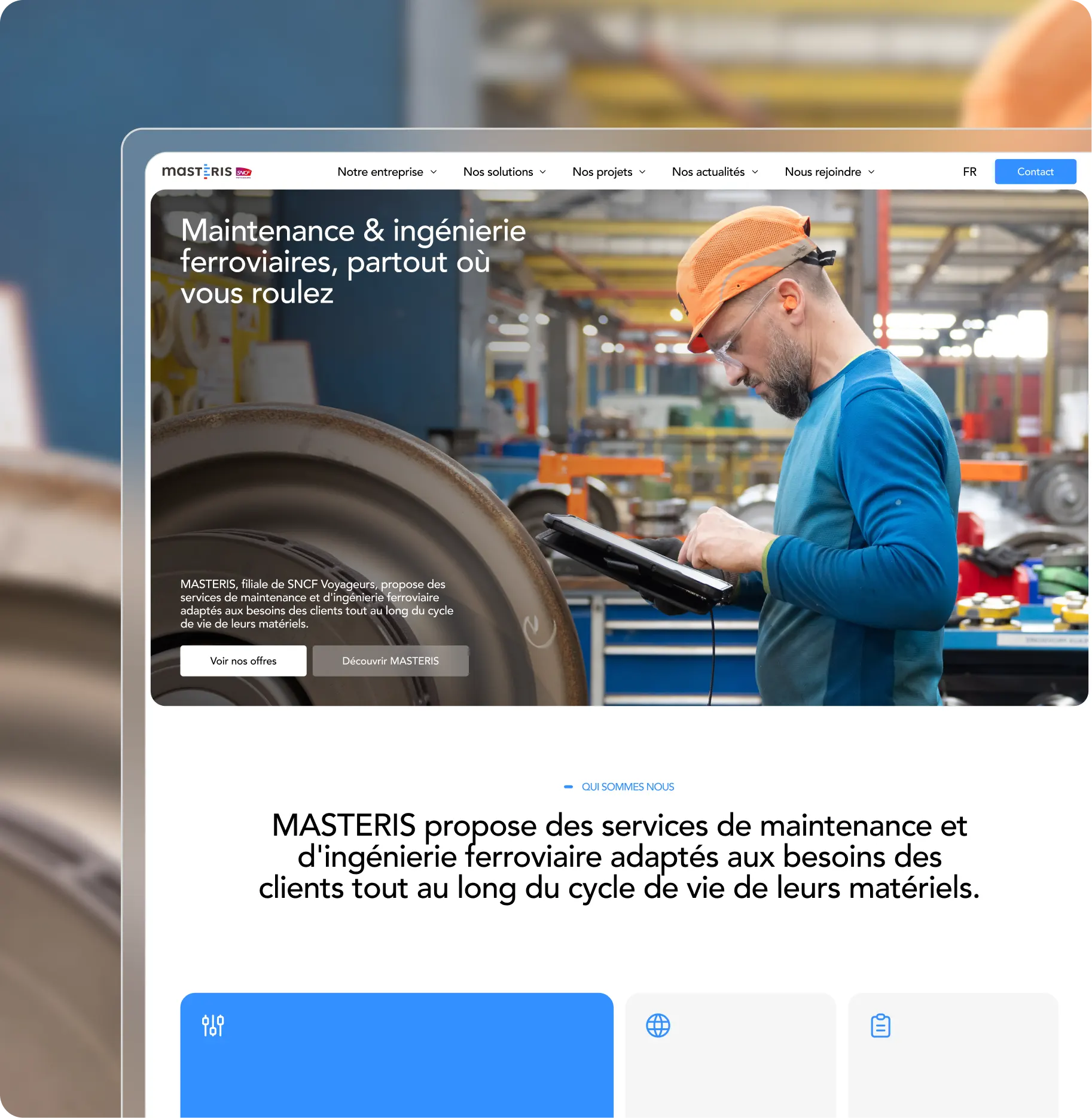 Un homme portant un casque orange et une chemise bleue utilise une tablette pour l'entretien des voies ferrées en milieu industriel.