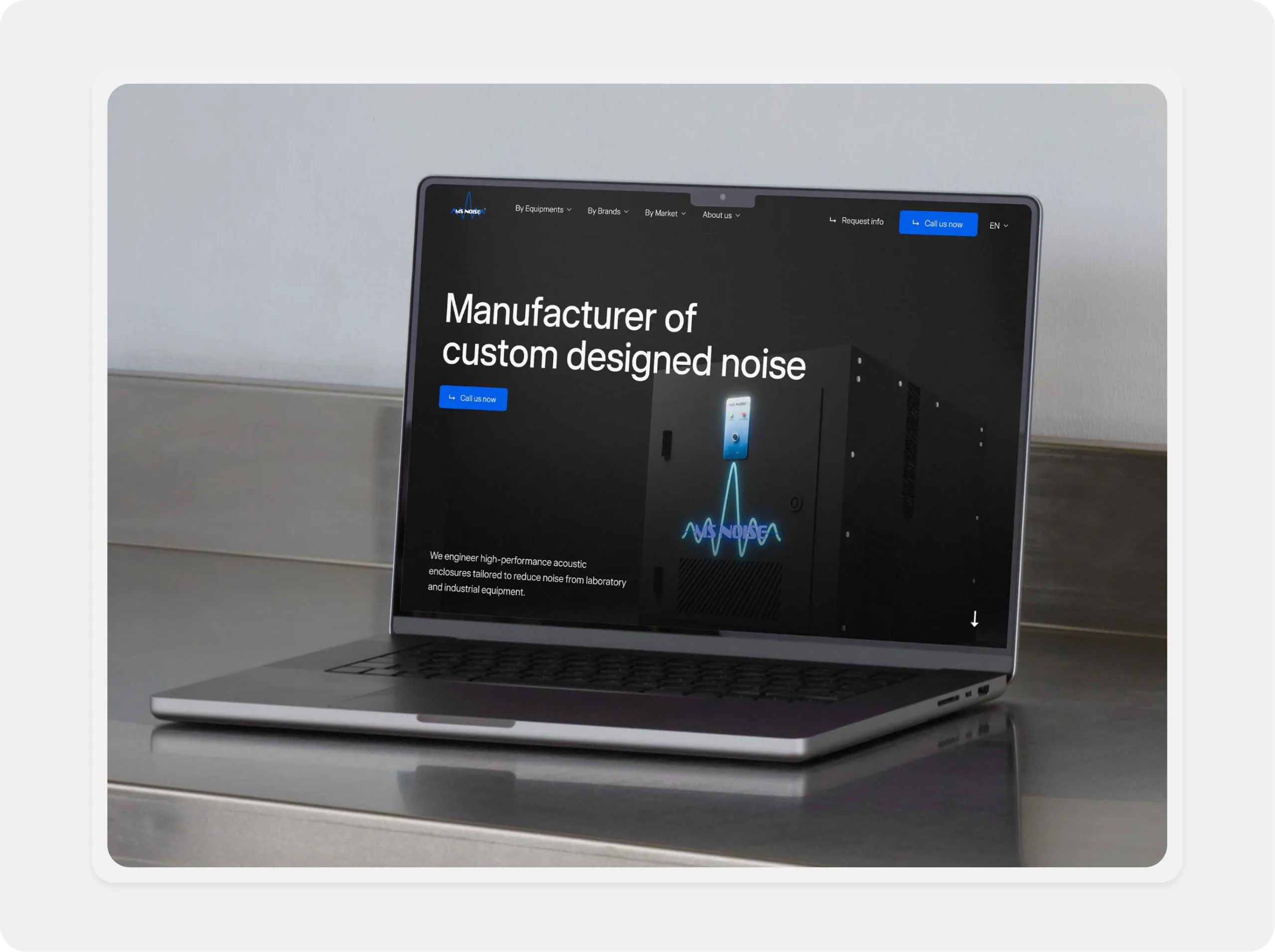 Laptop on metal surface displaying a website about custom-designed noise manufacturers.