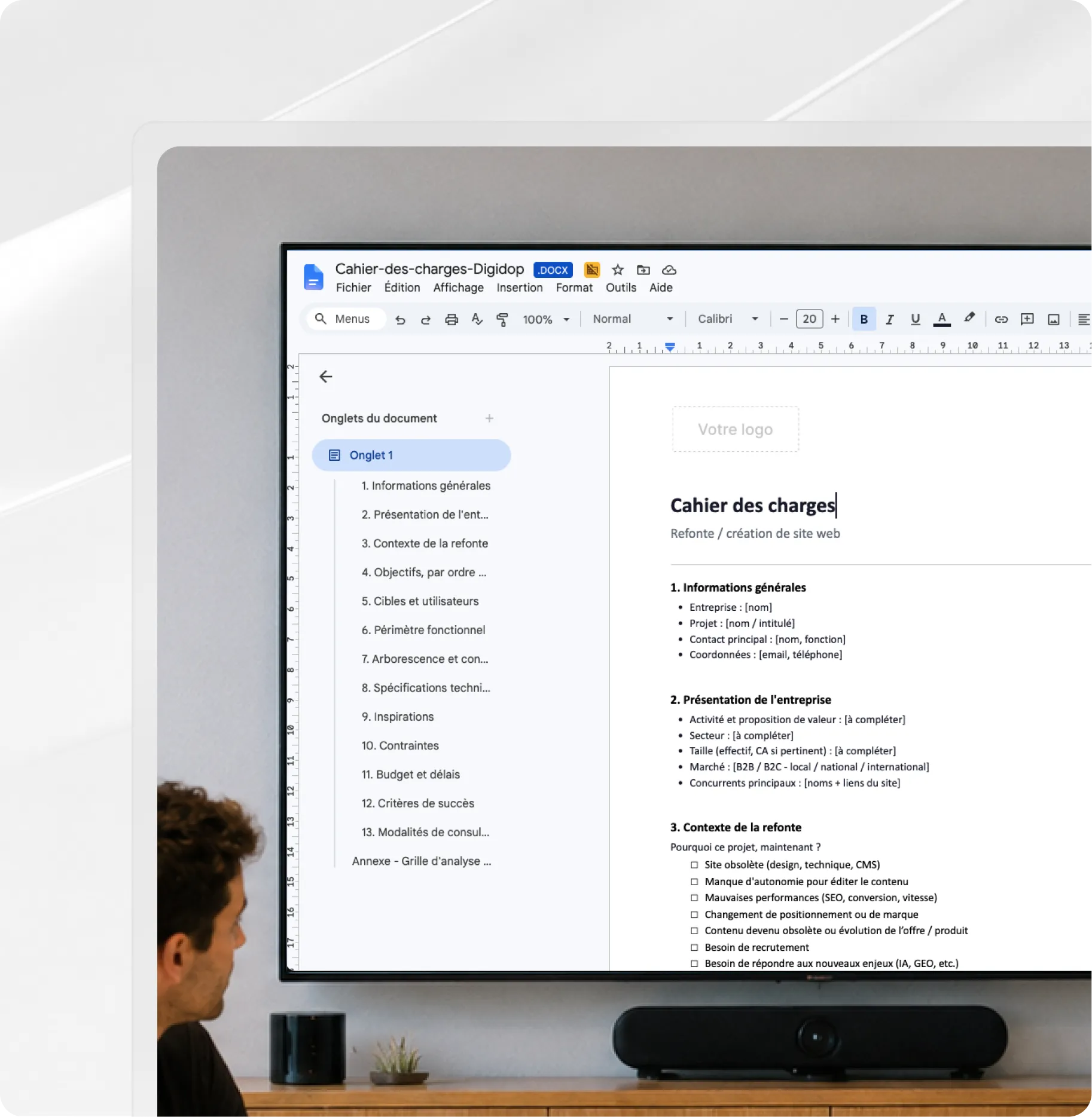 Personne regardant un grand écran affichant un éditeur de documents avec du contenu de planification de projet en français.
