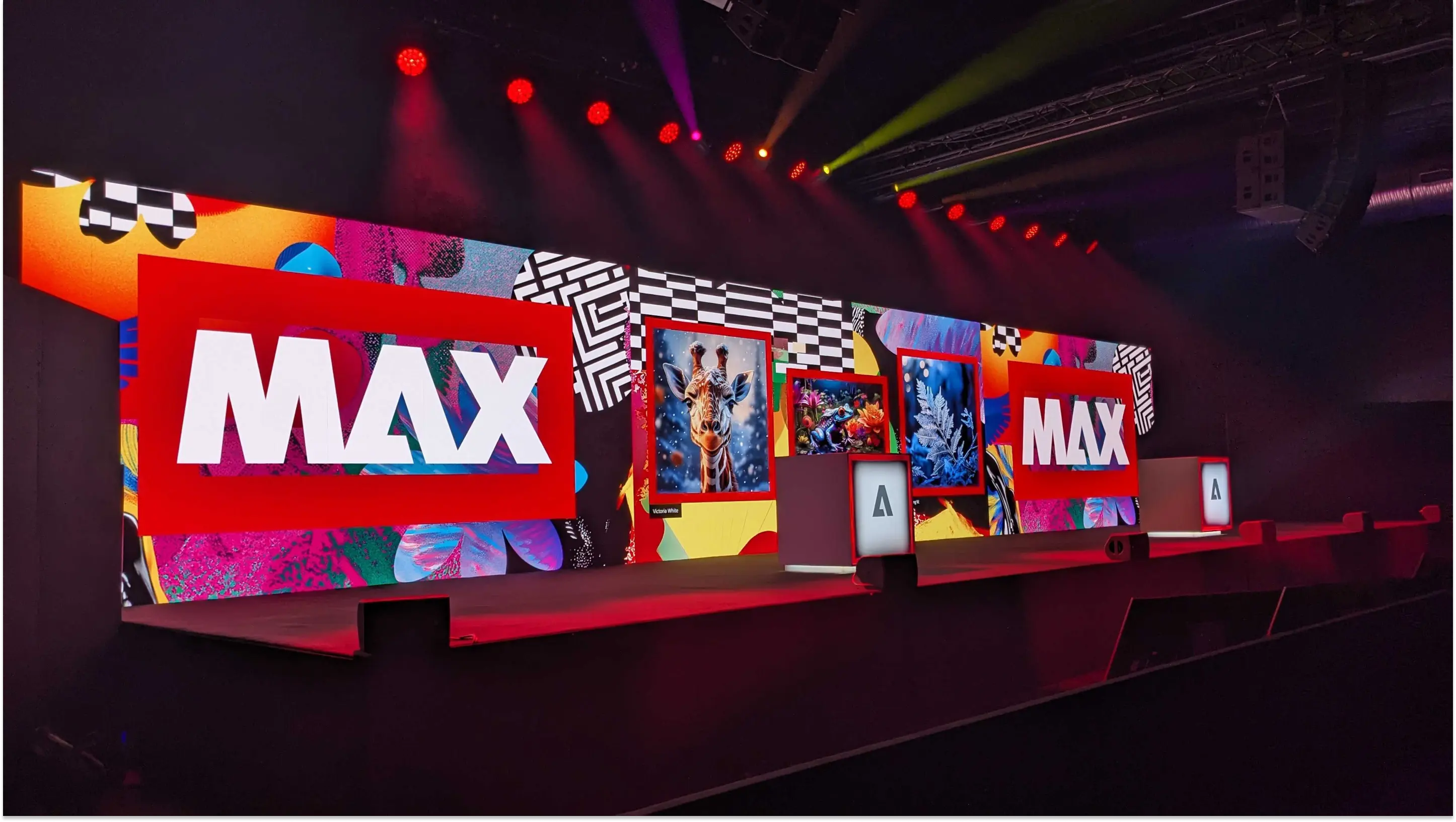 Vibrant stage at Adobe MAX 2025 with large screens displaying the logo and creative visuals.