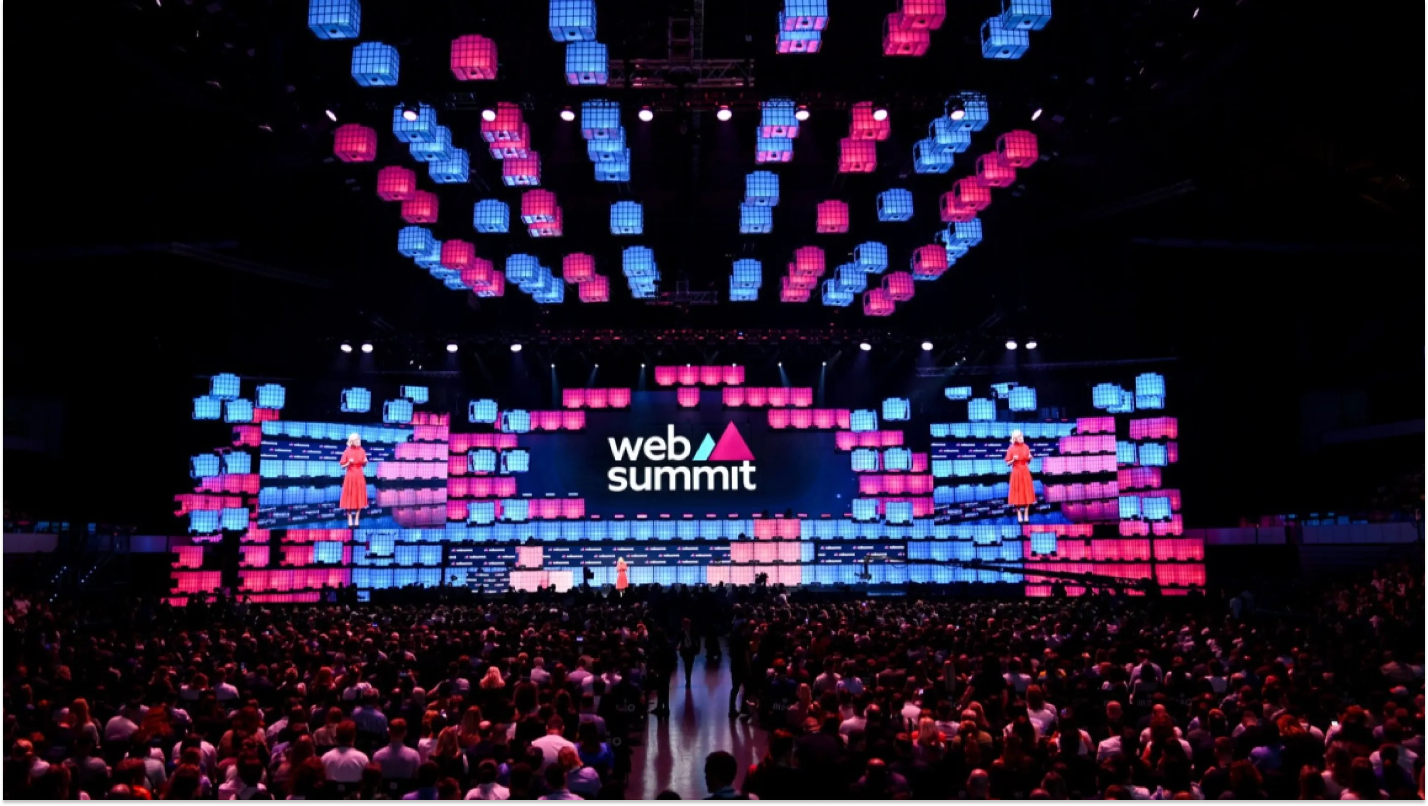 Opening ceremony of Web Summit 2025 in Lisbon, with a large illuminated stage and a packed audience.