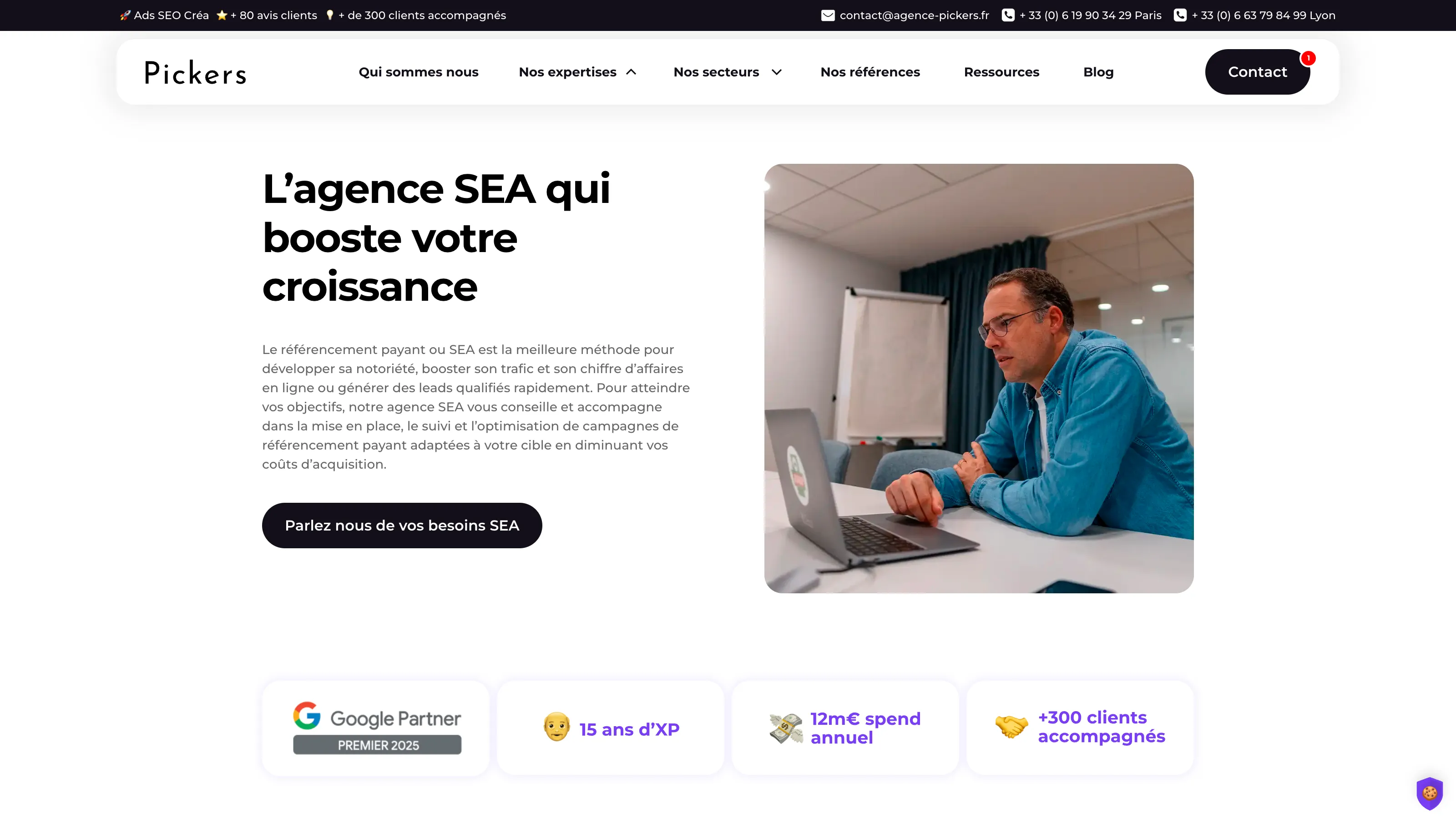 Consultant SEA travaillant sur un ordinateur portable dans une salle de réunion, illustrant les services d’acquisition digitale de l’agence Pickers.