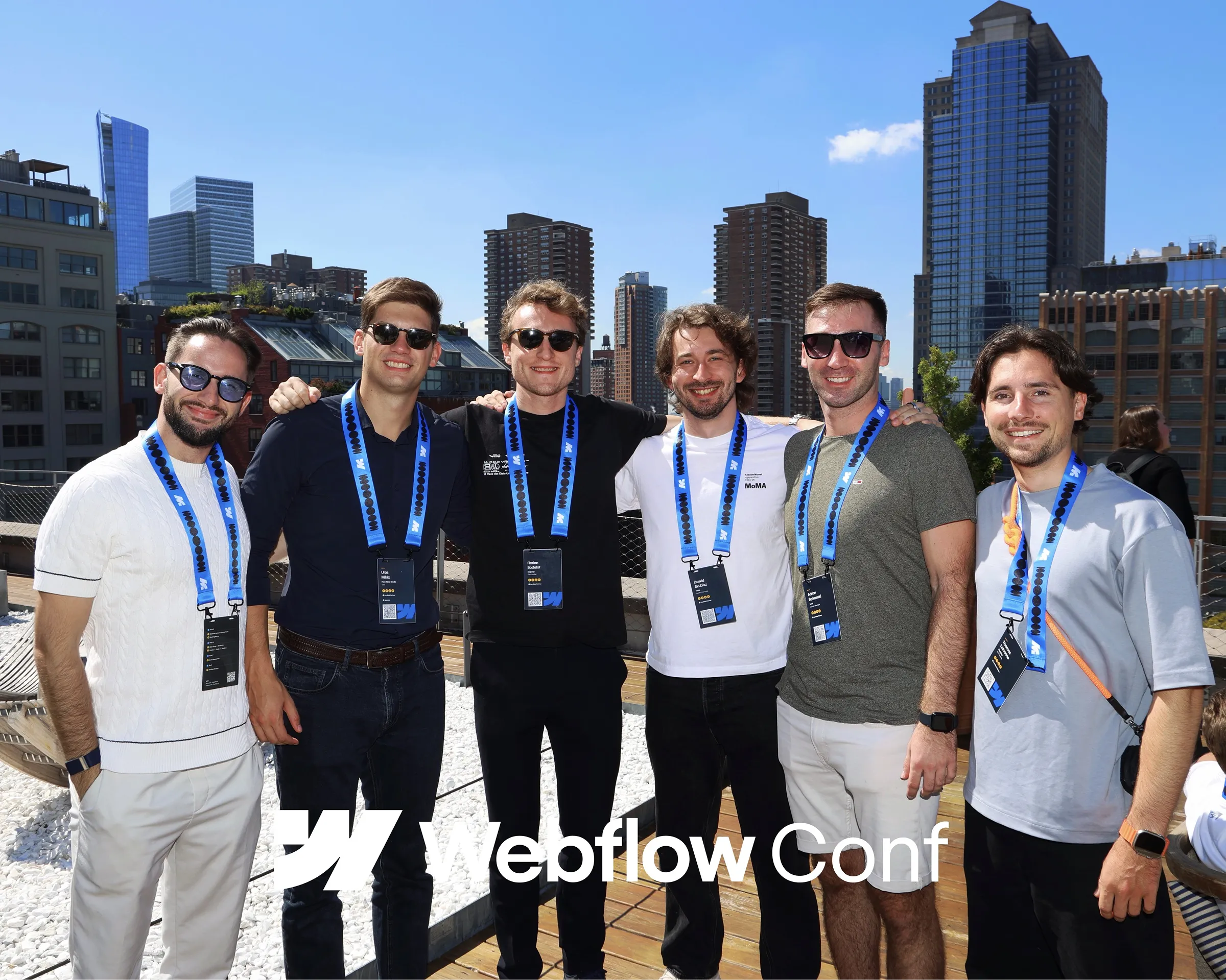 Photo de groupe prise sur un rooftop à New York pendant la Webflow Conf, réunissant des membres de Tonik (dont Dawid), de Flow Ninja (Uroš), et de Digidop (Thomas et Florian). Tous portent les badges de la conférence avec les gratte-ciel en arrière-plan.