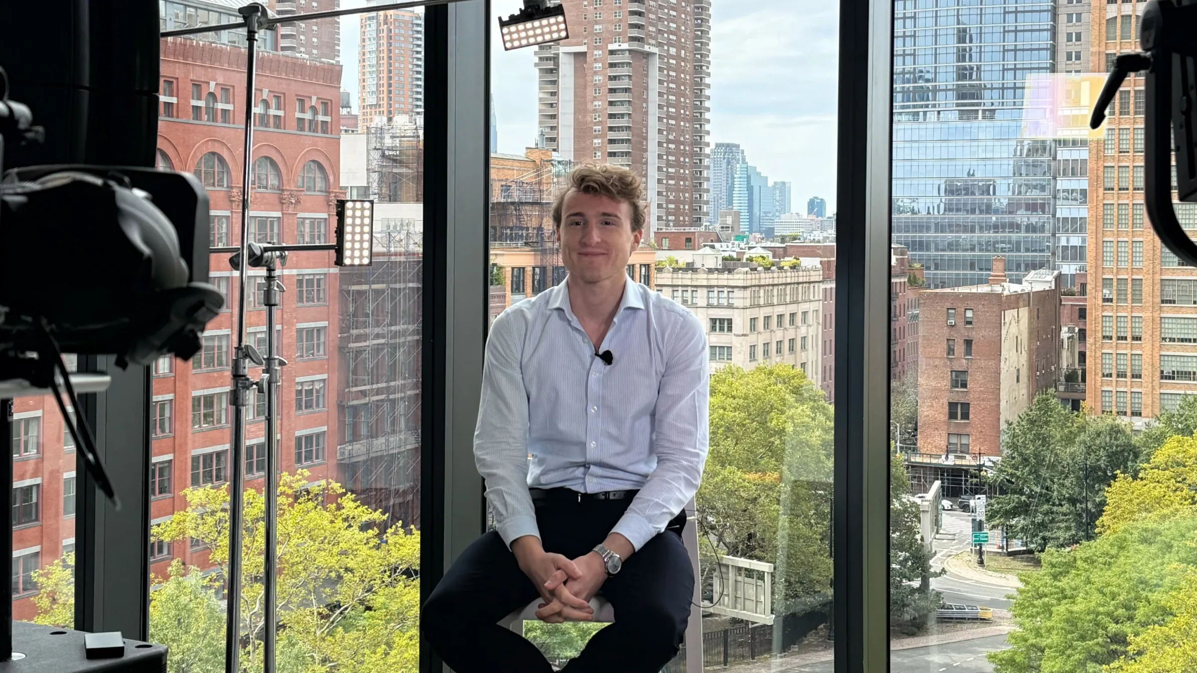 Florian Bodelot filmé lors d’une interview à la Webflow Conf 2025, assis sur un tabouret face caméra, avec les gratte-ciel de New York en arrière-plan à travers de grandes baies vitrées.