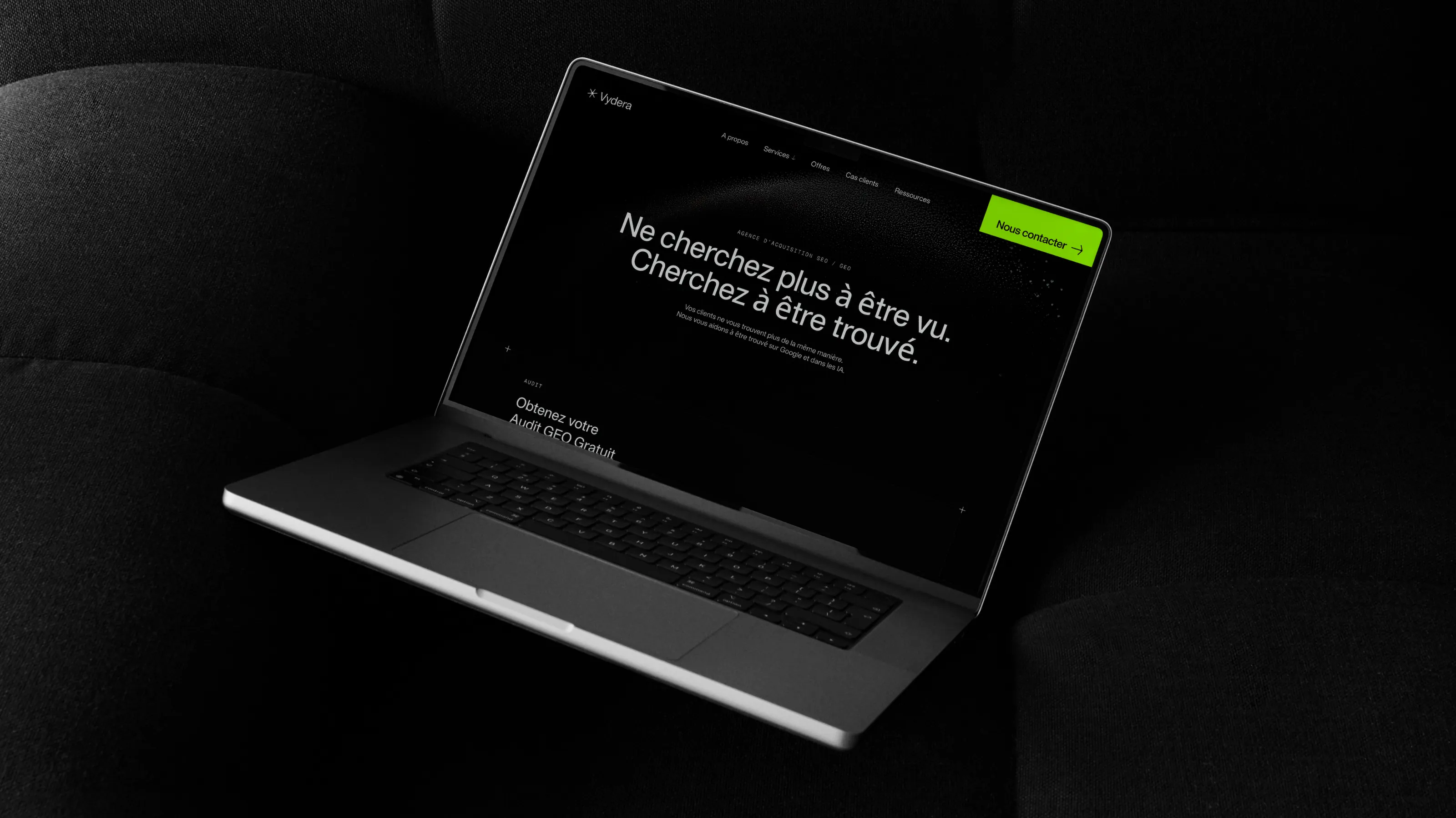 Site Web de l'agence SEO & GEO Vydera affiché sur un ordinateur posé sur un coussin, avec le titre « Ne cherchez plus à être vu. Cherchez à être trouvé. »