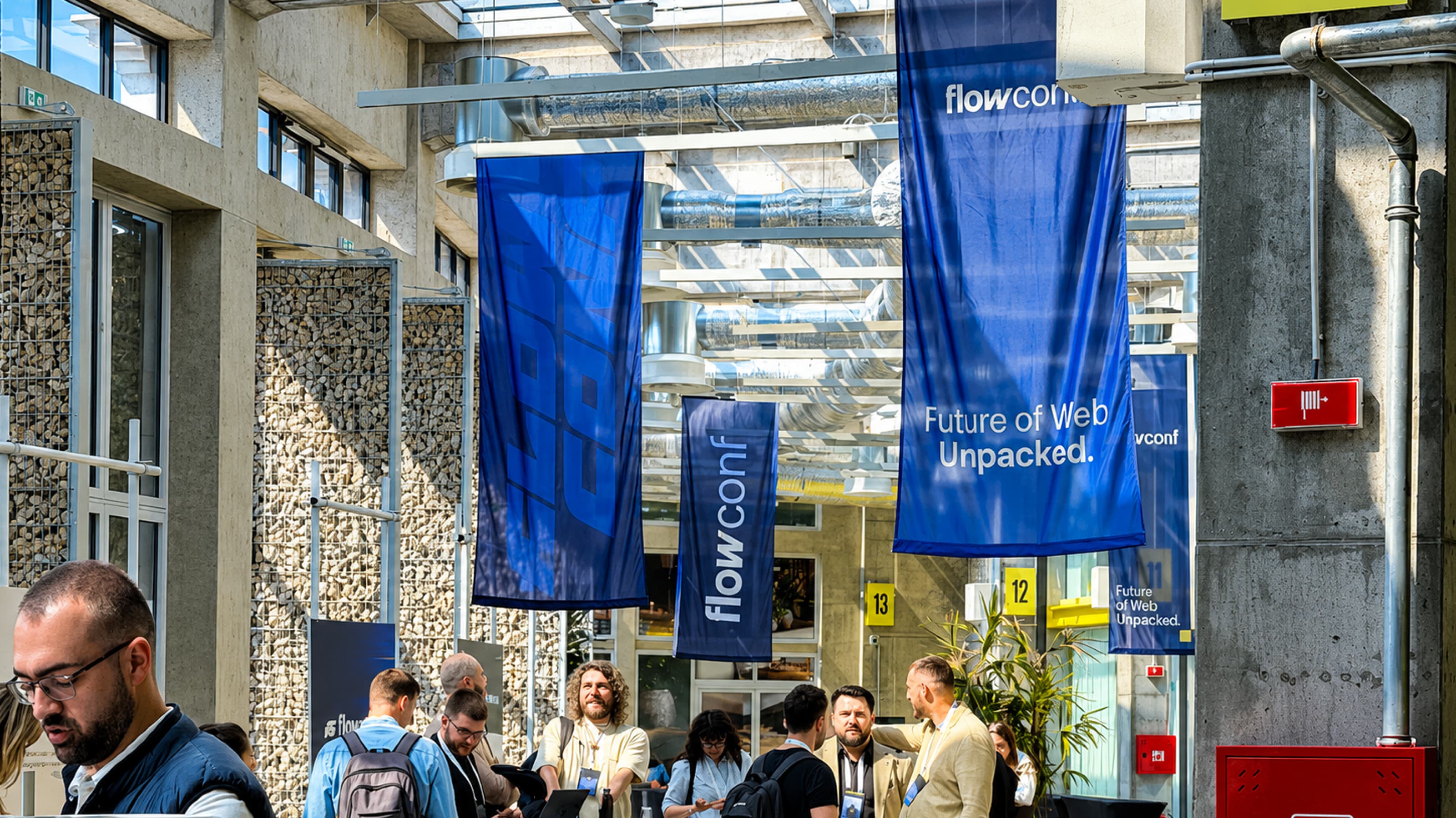Participants networking during flowConf 2026 in Belgrade, a European conference focused on the future of web, Webflow, and AI, inside a modern industrial venue featuring “Future of Web Unpacked” banners.