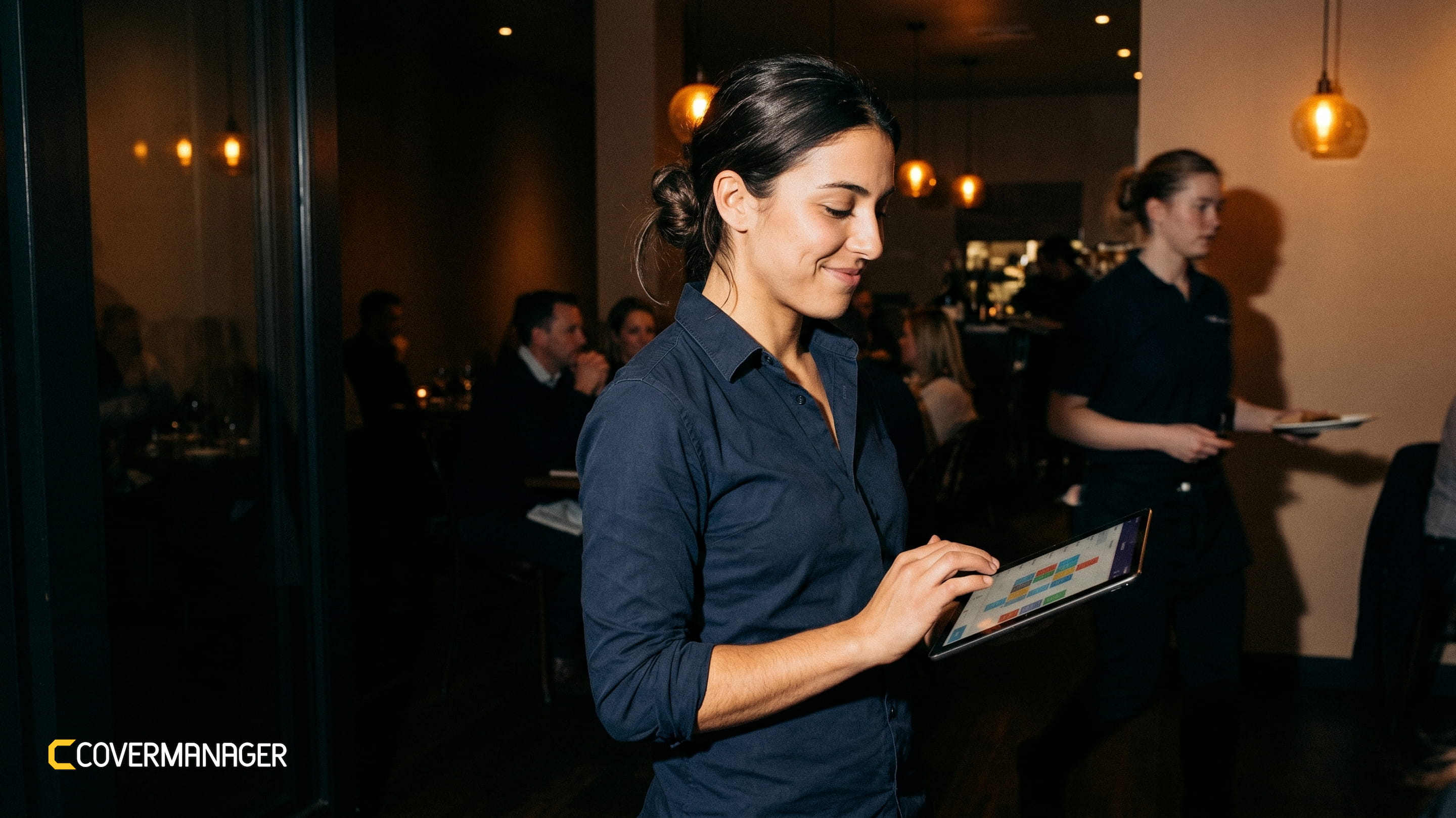 Restaurant staff member using the CoverManager platform on a tablet, illustrating digital reservation management solutions for hospitality businesses.