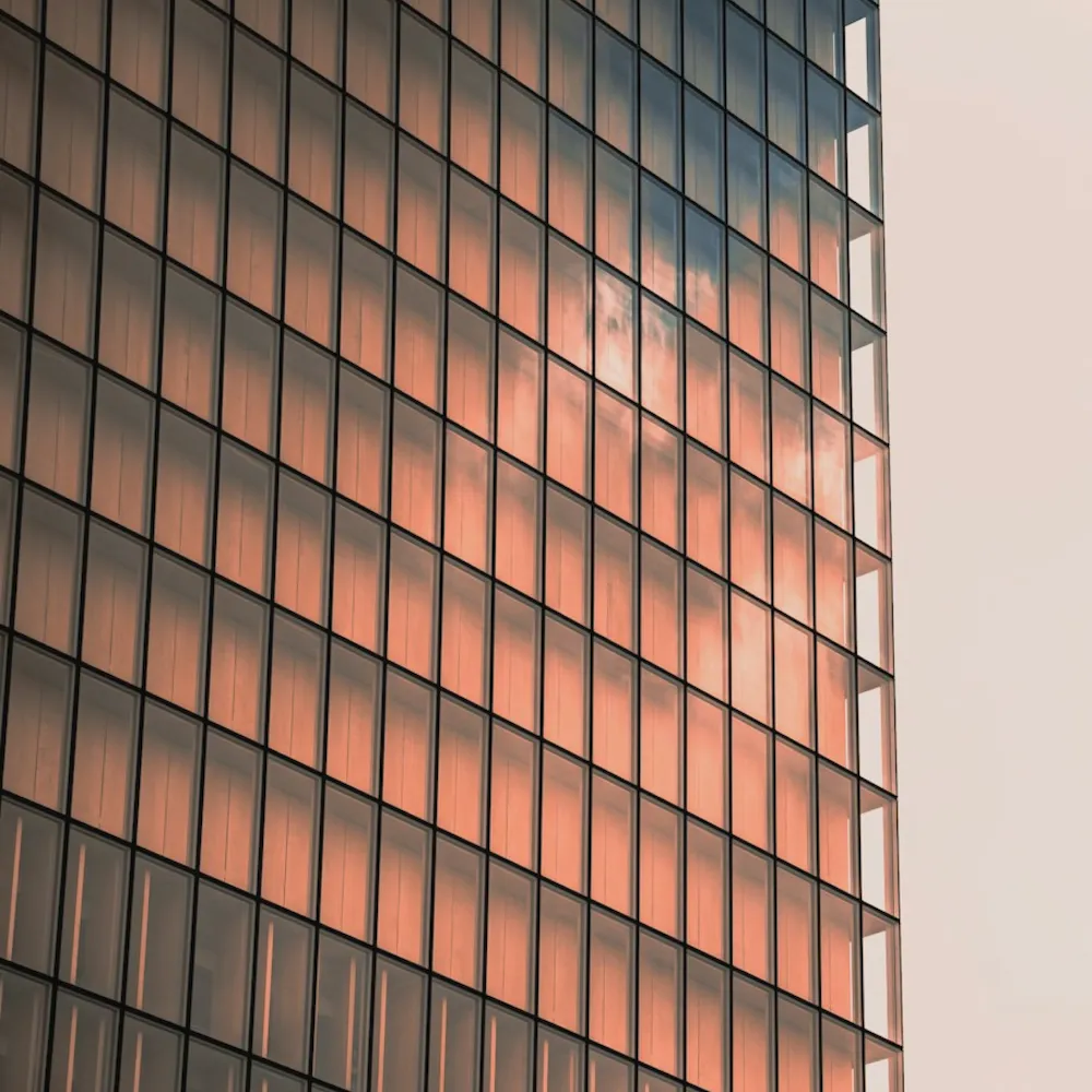 Glass facade of an office building reflecting the sunset