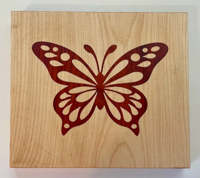 A V-carve inlay with a contrasting wood plug seated in a pocket