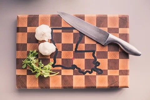 An end grain checkerboard cutting board with a state outline filled in dark epoxy.