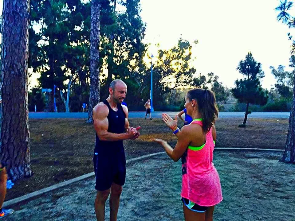 Justin coaching a client through a partner drill at an outdoor group session