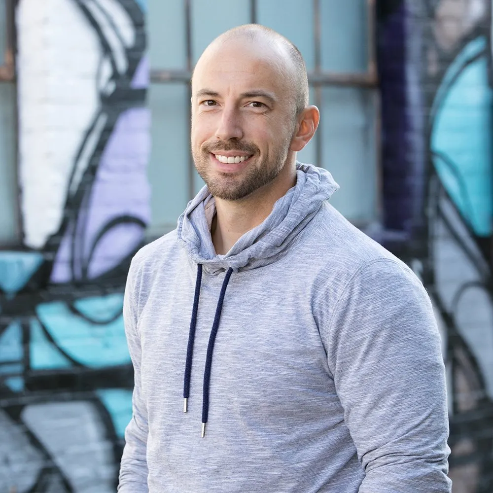 Justin Kraft, smiling, in a grey hoodie