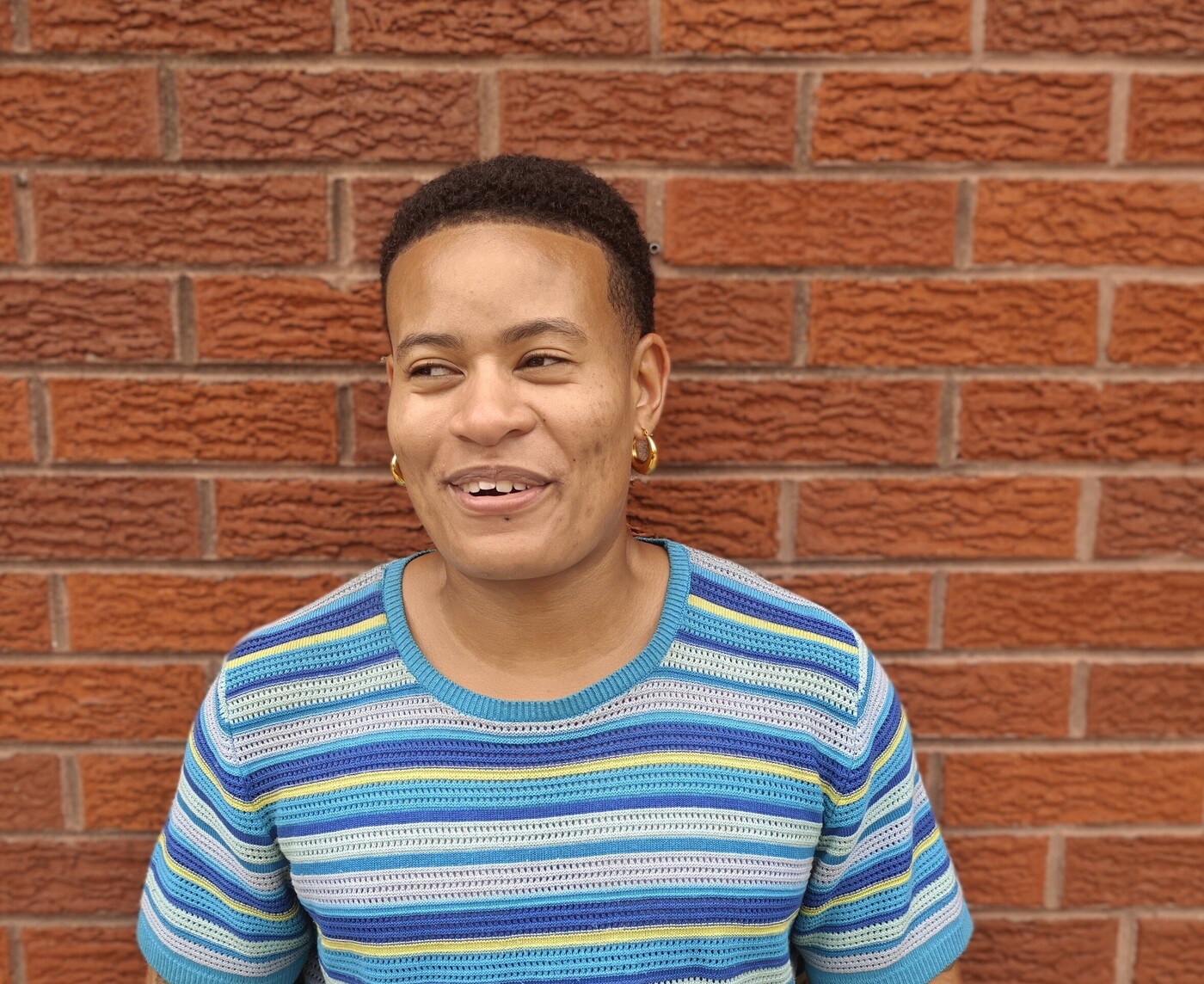 A person wearing  a striped blue and yellow shirt