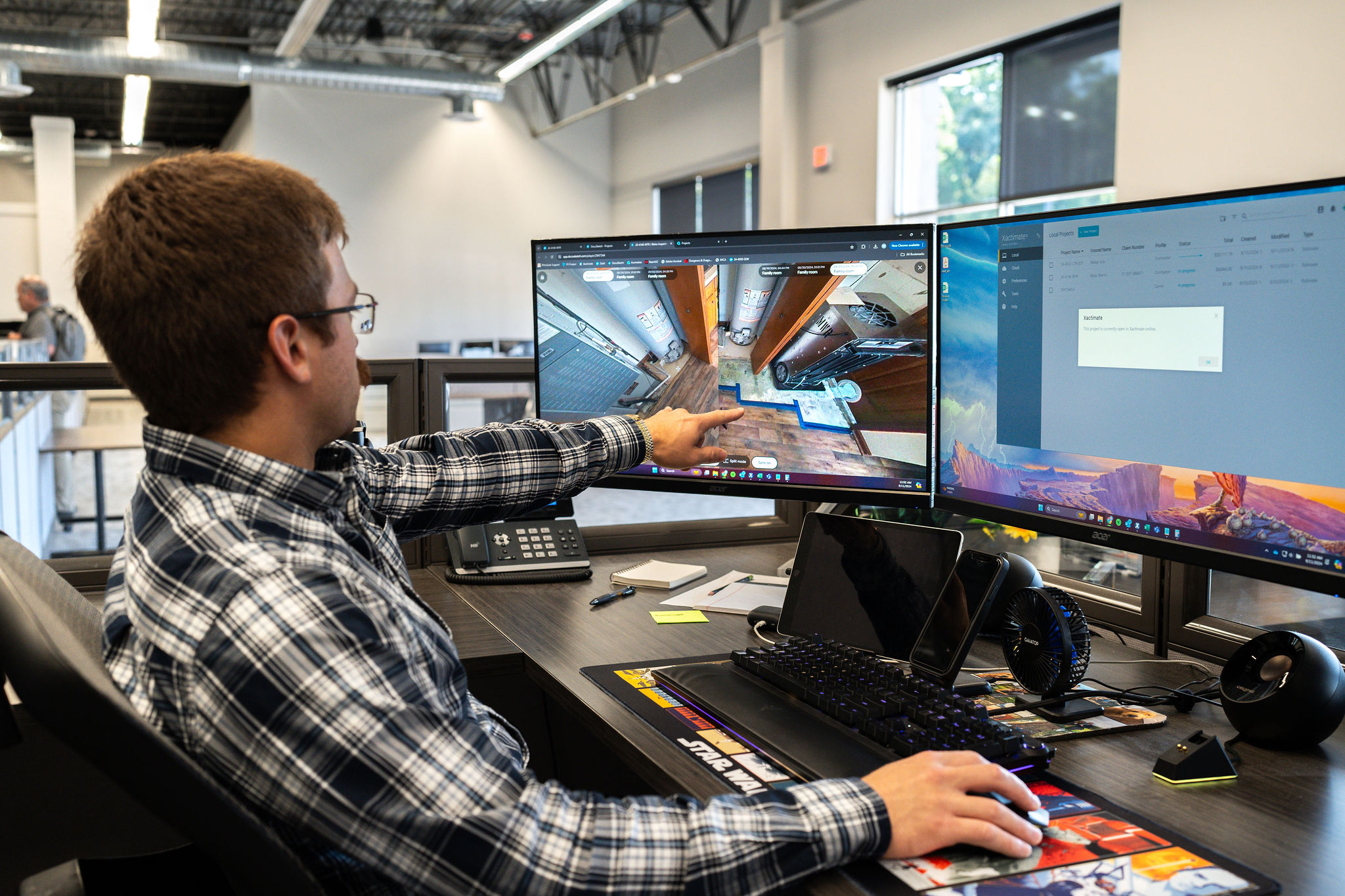 A person points to a digital job site walkthrough on a computer monitor.