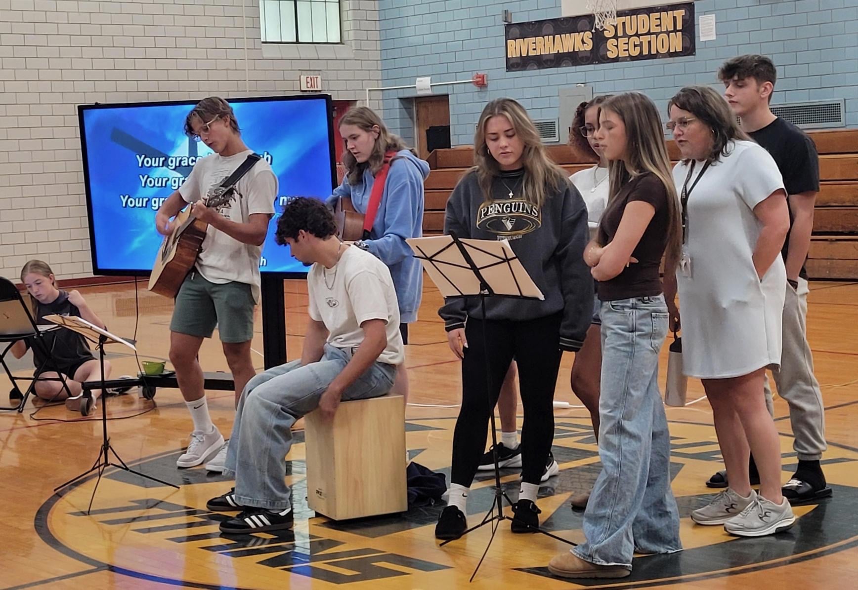 High school Graduation caps on a gymnasium floor with confetti and a basketball