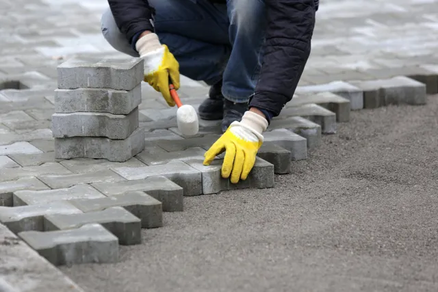 Desert Rock Masonry worker laying stone pavers and custom brickwork in Gilbert AZ