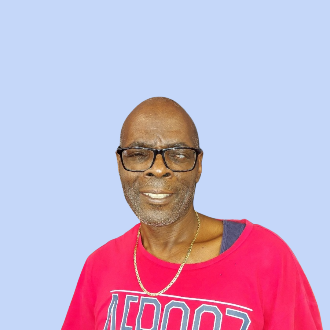 Mr. Rupert smiling in a red shirt against blue background