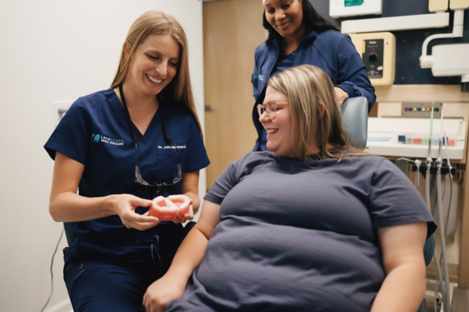 Dentist showing patient model teeth during consultation about sedation options