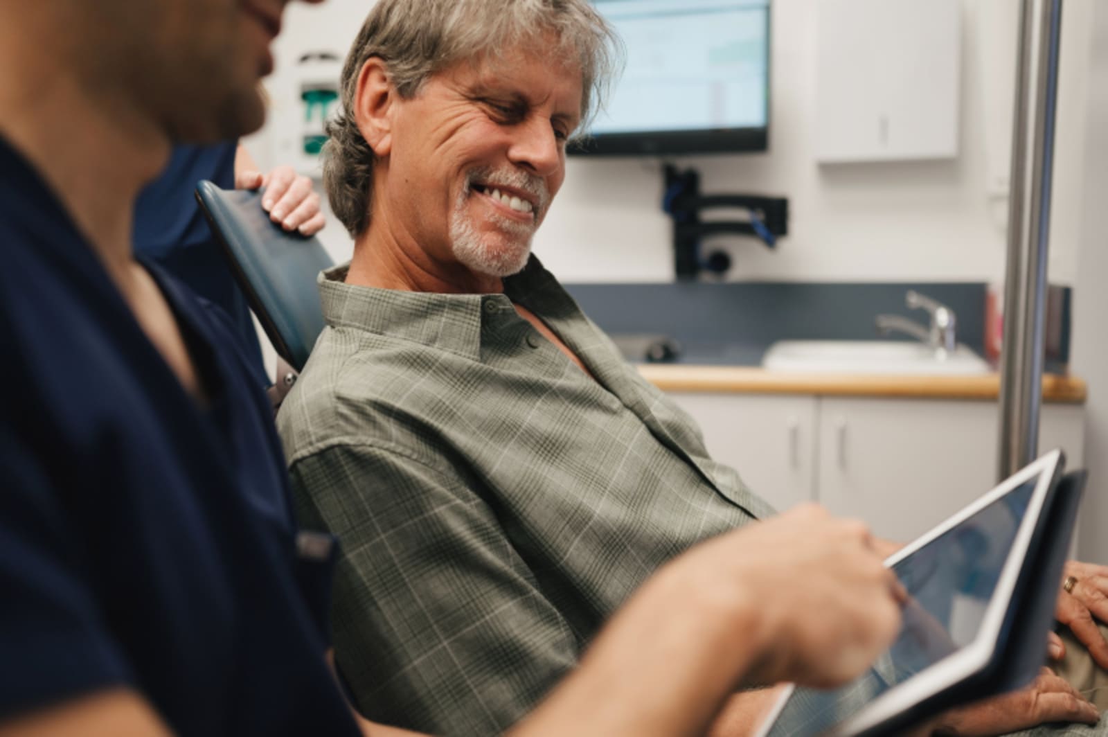 Dental professional smiling with patient in consultation room